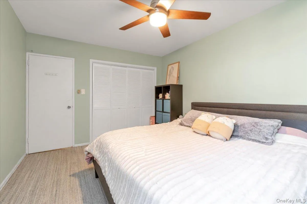 Bedroom featuring light carpet, a closet, and a ceiling fan Bedroom featuring light carpet, a closet, and a ceiling fan