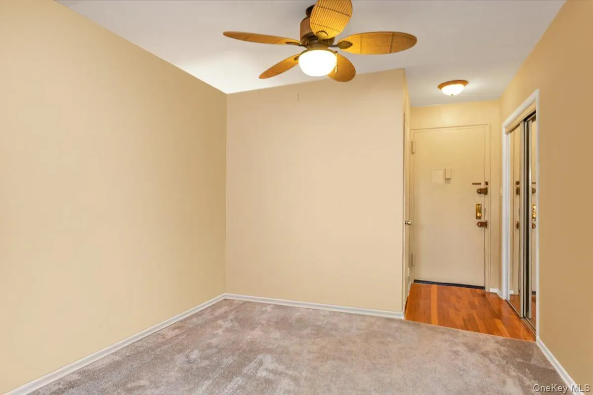Carpeted spare room featuring ceiling fan and baseboards Carpeted spare room featuring ceiling fan and baseboards
