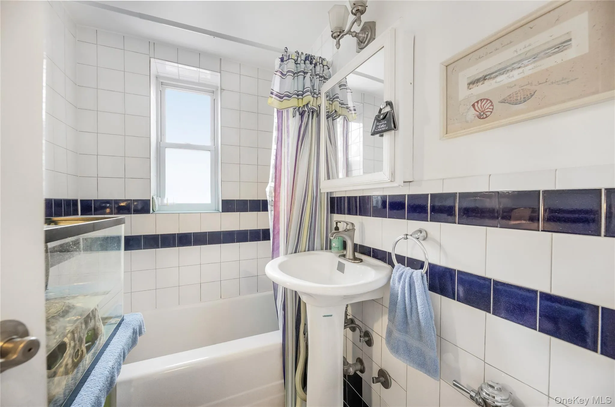 Full bathroom with tile walls and shower / bath combination with curtain Full bathroom with tile walls and shower / bath combination with curtain