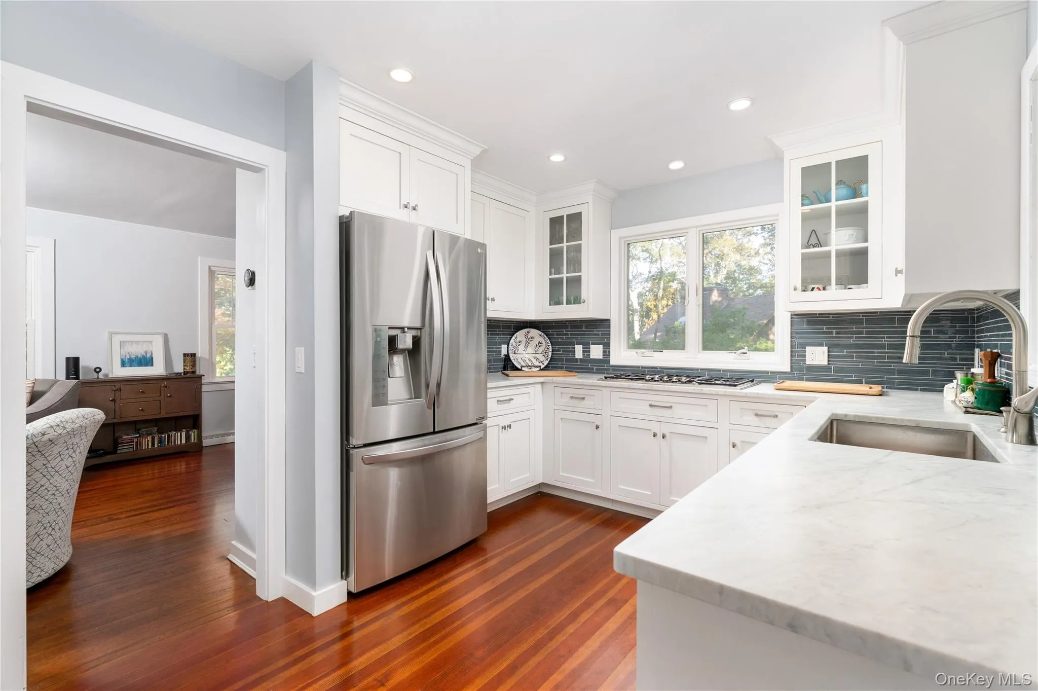 Kitchen with white cabinets, stainless steel appliances, light stone countertops, tasteful backsplash, and healthy amount of natural light Kitchen with white cabinets, stainless steel appliances, light stone countertops, tasteful backsplash, and healthy amount of natural light