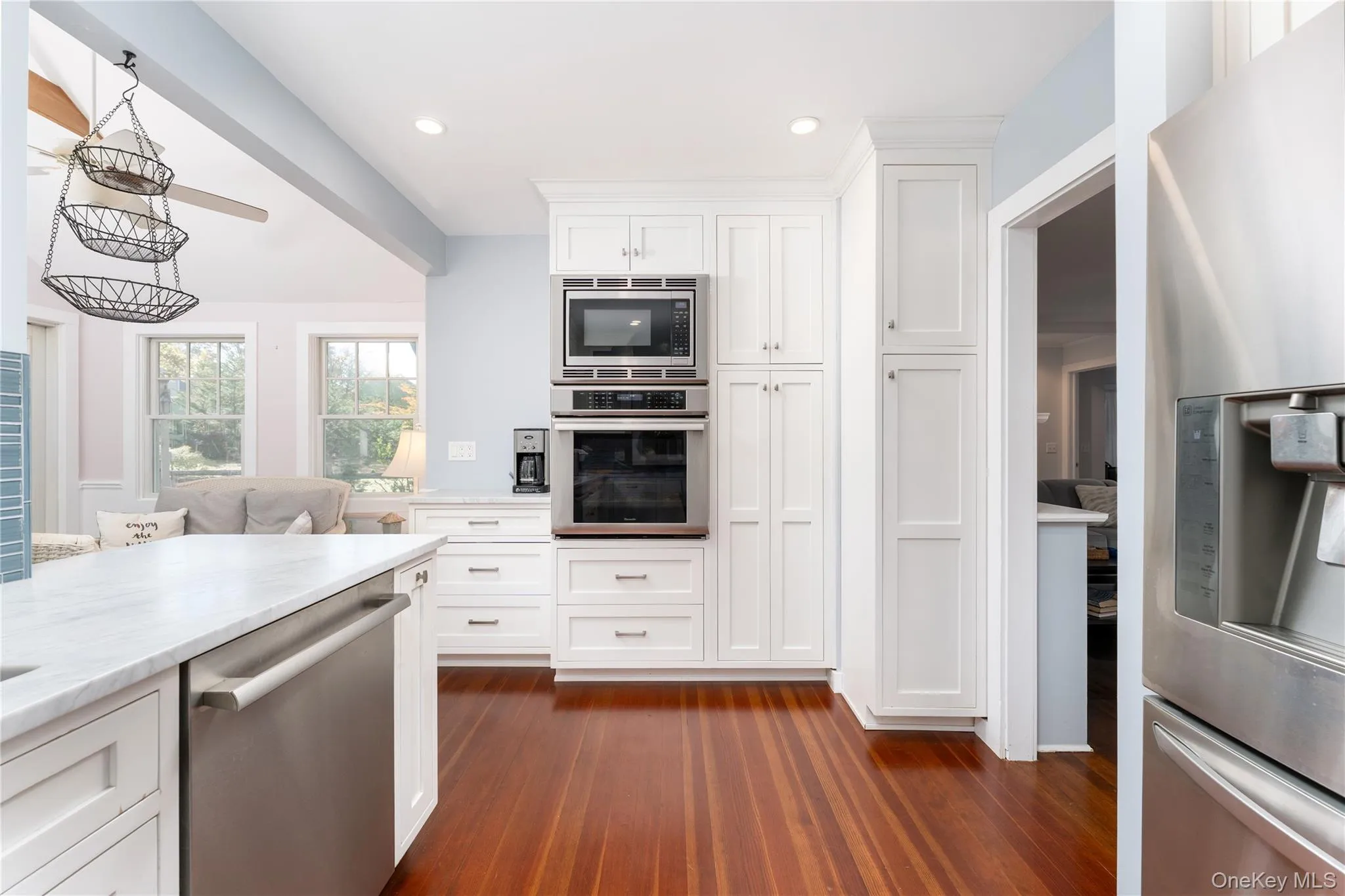 Kitchen featuring appliances with stainless steel finishes, white cabinets, dark wood-type flooring, decorative light fixtures, and recessed lighting Kitchen featuring appliances with stainless steel finishes, white cabinets, dark wood-type flooring, decorative light fixtures, and recessed lighting