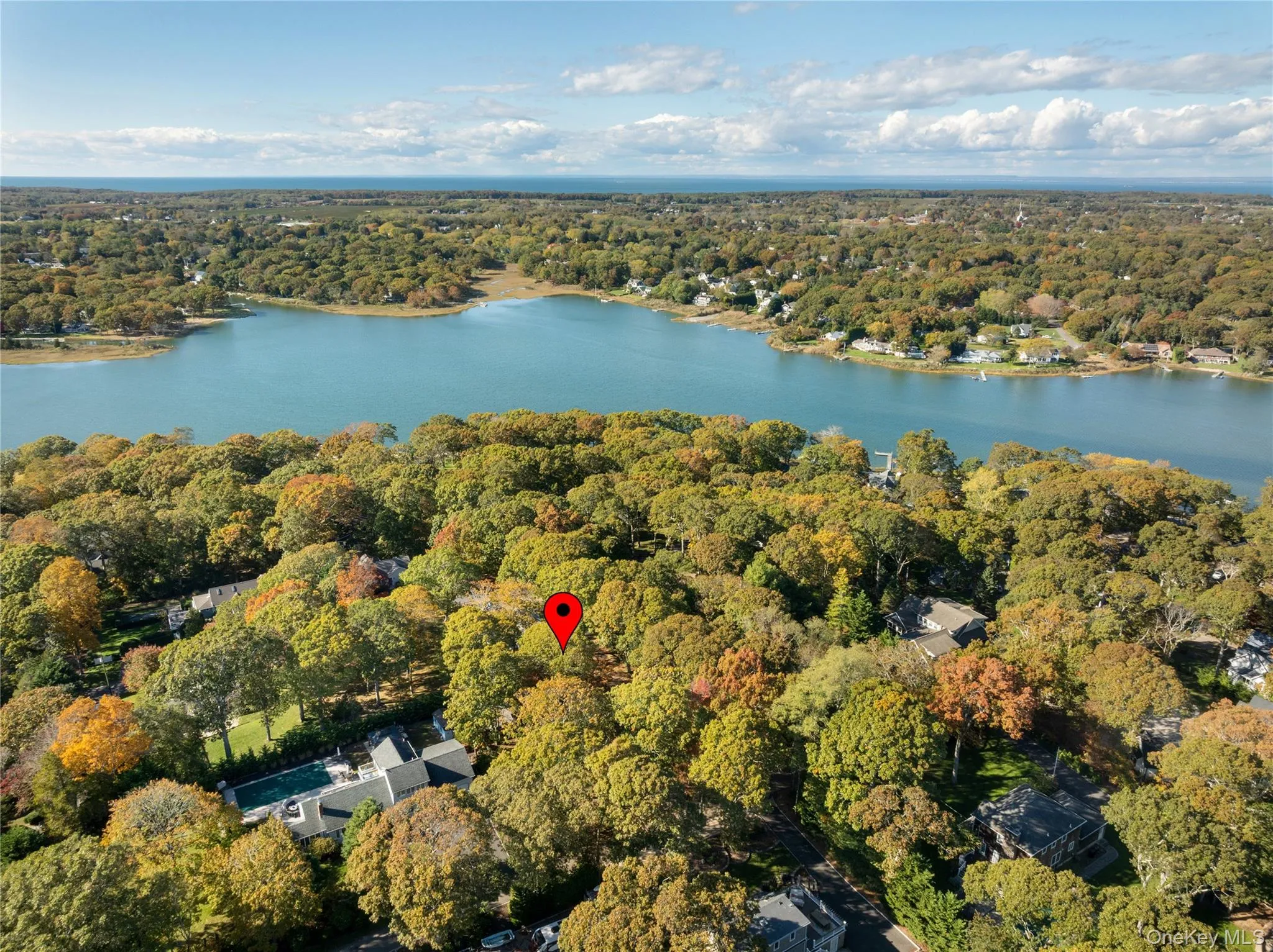 Aerial view of property and surrounding area featuring a forest and a nearby body of water Aerial view of property and surrounding area featuring a forest and a nearby body of water