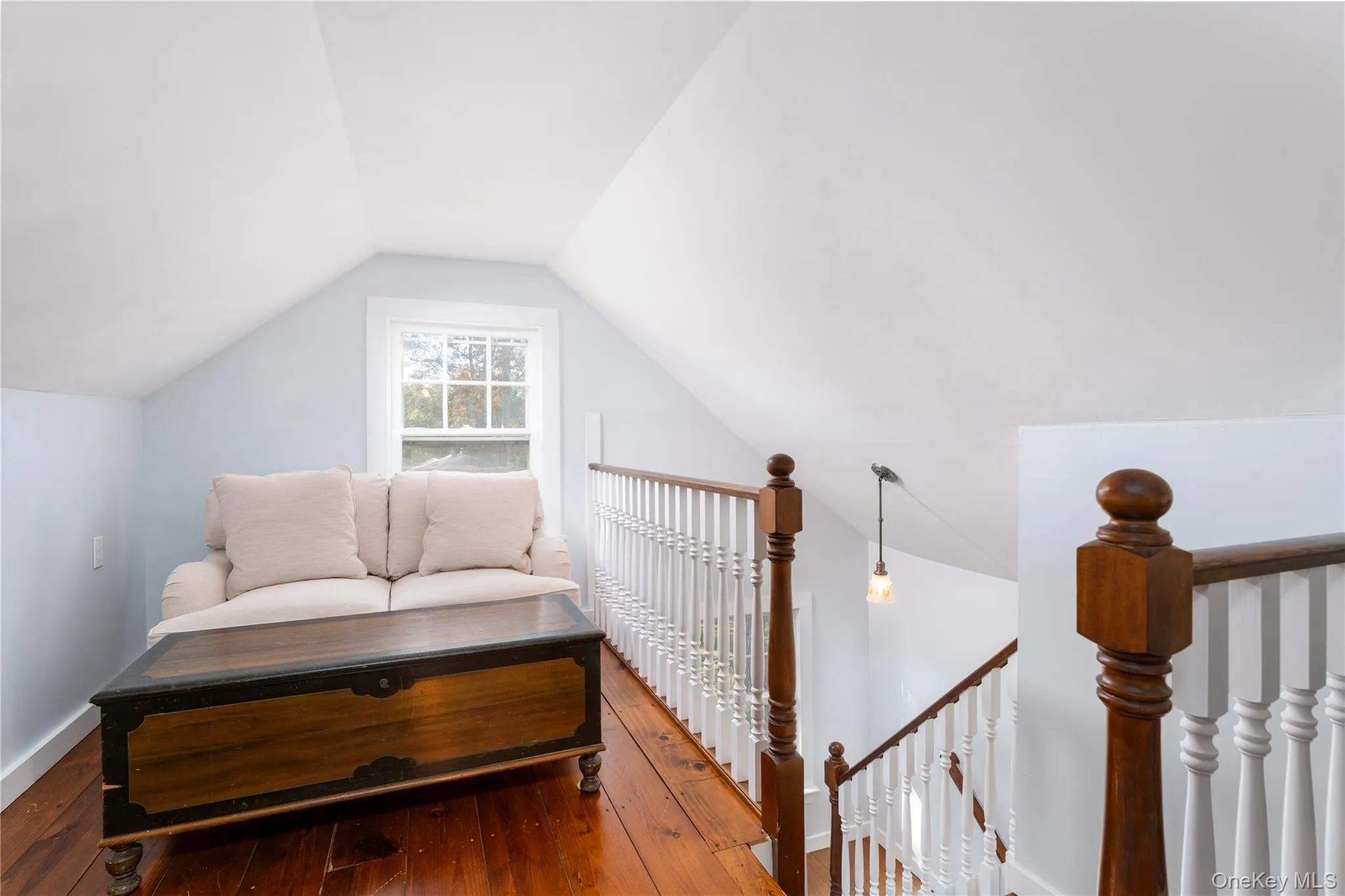 Sitting room with lofted ceiling, hardwood / wood-style floors, and an upstairs landing Sitting room with lofted ceiling, hardwood / wood-style floors, and an upstairs landing