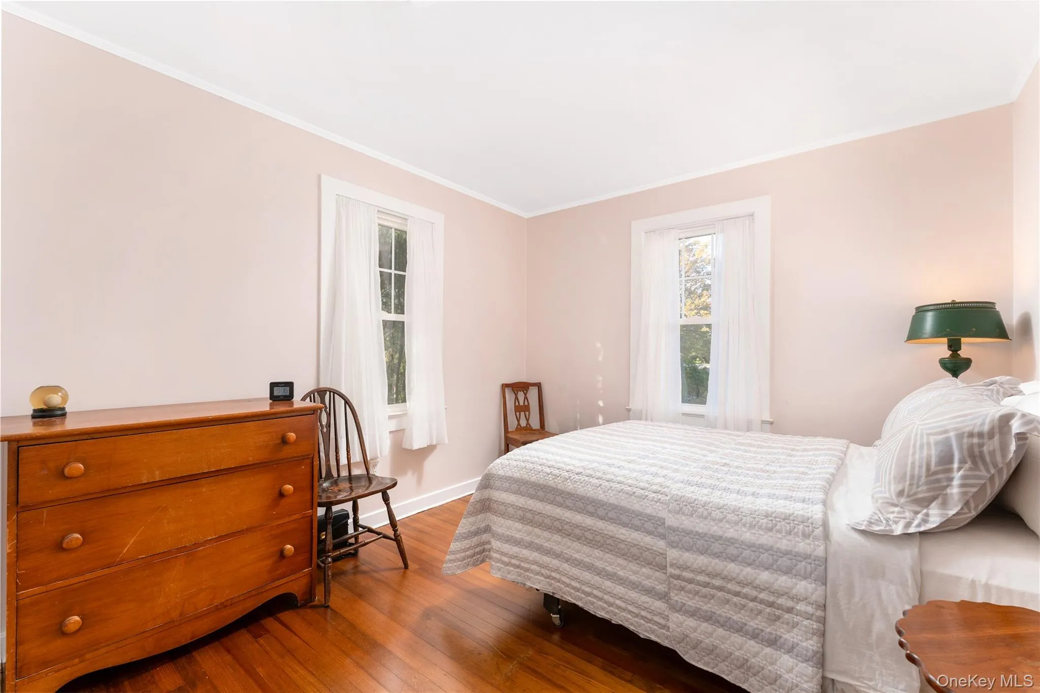 Bedroom with ornamental molding and wood finished floors Bedroom with ornamental molding and wood finished floors