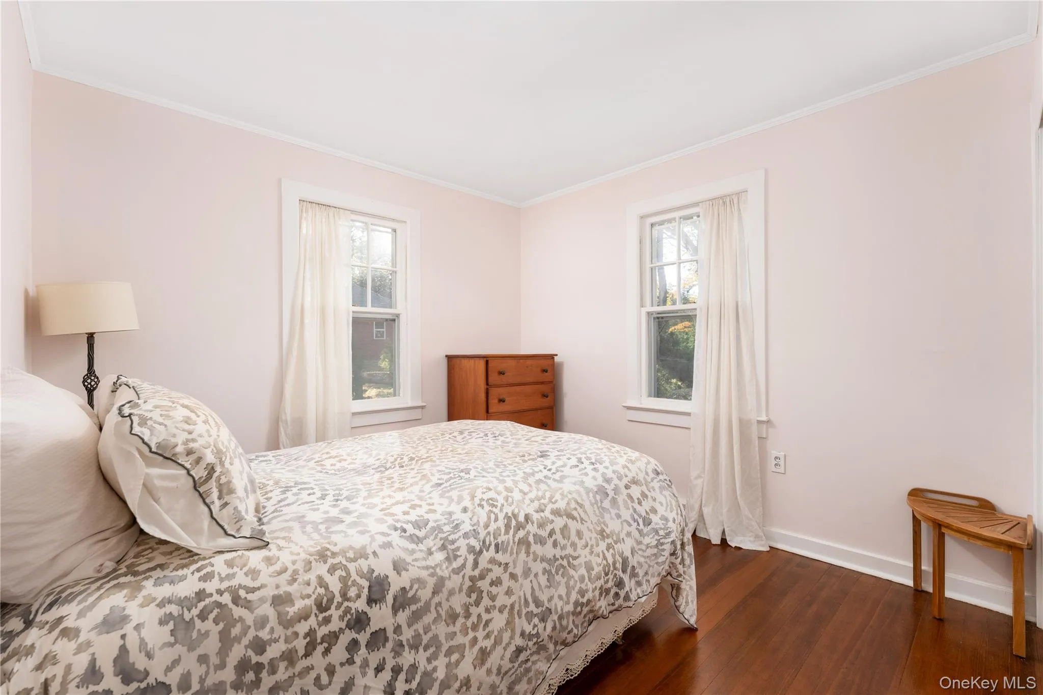 Bedroom with crown molding and dark wood-style floors Bedroom with crown molding and dark wood-style floors