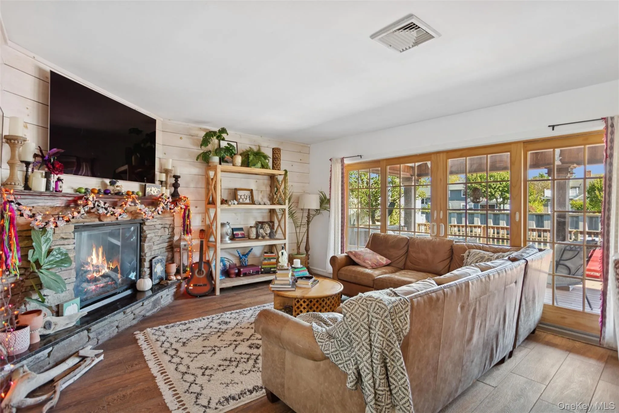 Living room with wood finished floors, a fireplace, and wood walls Living room with wood finished floors, a fireplace, and wood walls