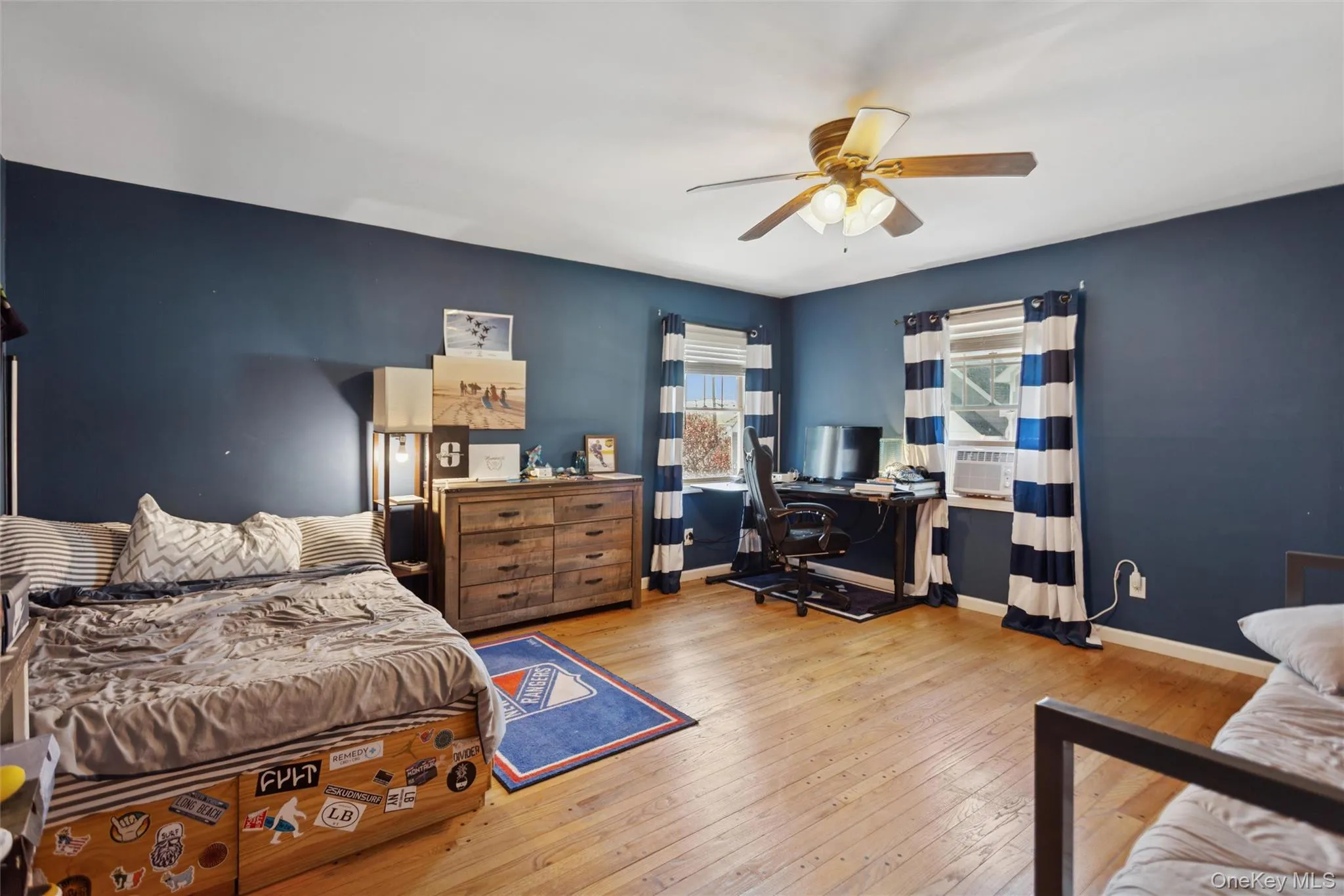 Bedroom with hardwood / wood-style floors, a desk, and a ceiling fan Bedroom with hardwood / wood-style floors, a desk, and a ceiling fan