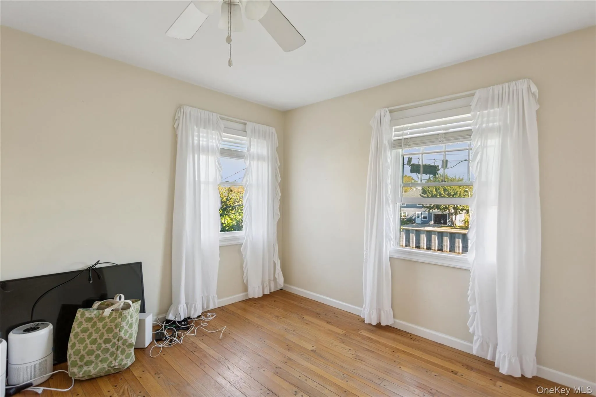 Unfurnished room with light wood-type flooring and baseboards Unfurnished room with light wood-type flooring and baseboards