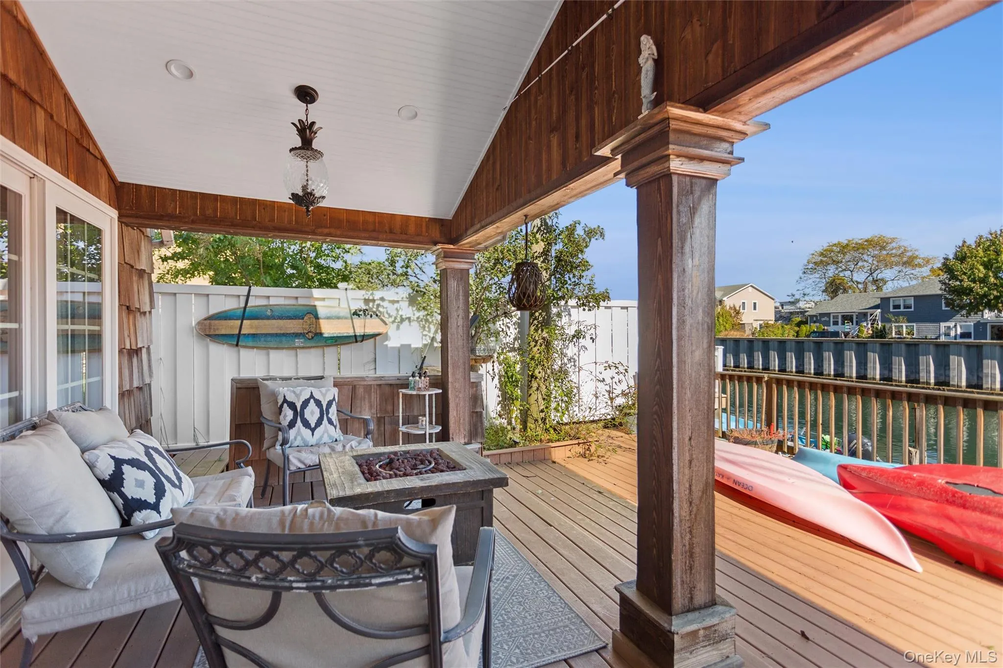 Deck featuring a hot tub, a fenced backyard, a water view, an outdoor living space with a fire pit, and a residential view Deck featuring a hot tub, a fenced backyard, a water view, an outdoor living space with a fire pit, and a residential view