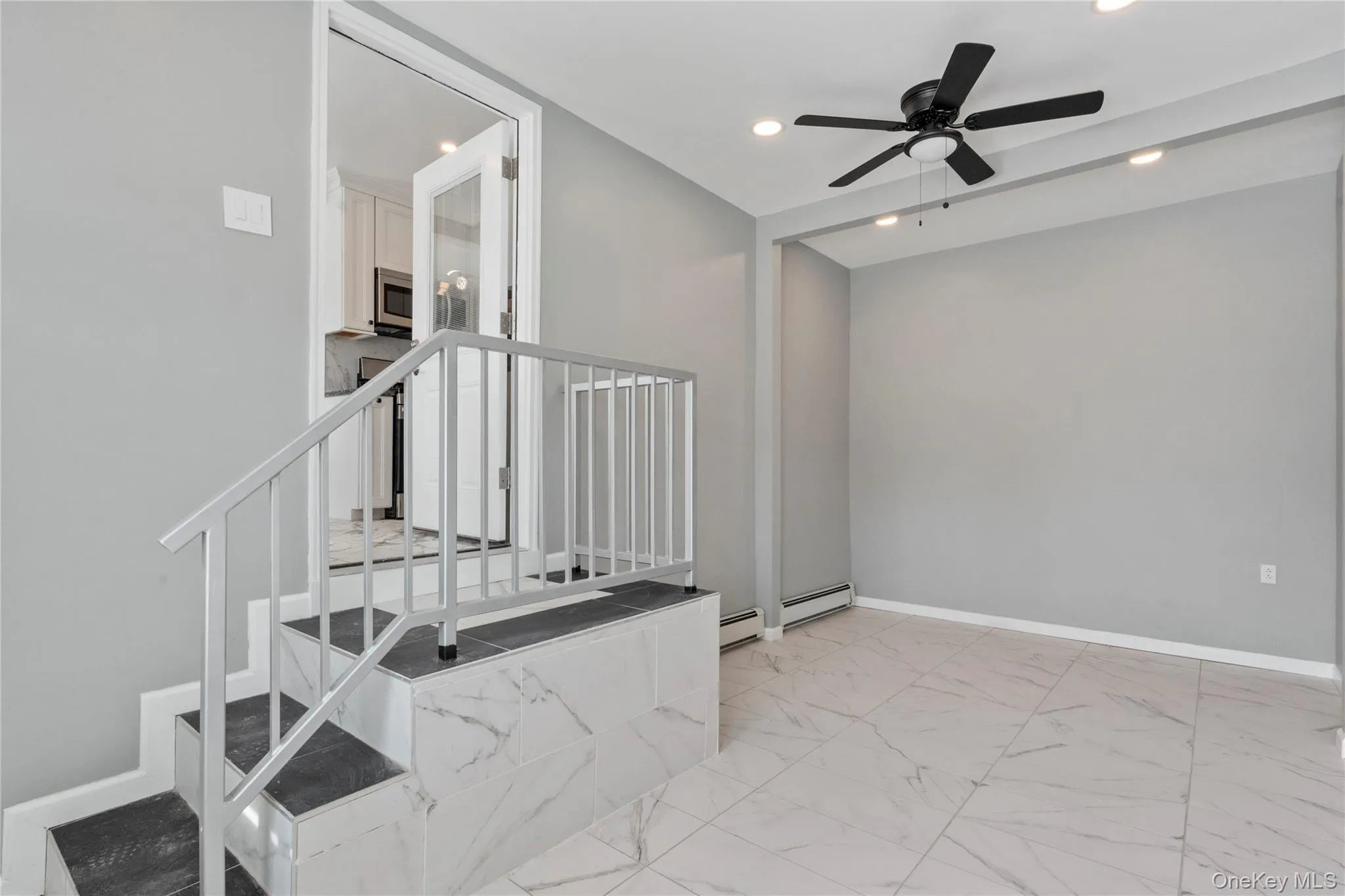 Stairs with marble finish floors, recessed lighting, a ceiling fan, and a baseboard radiator Stairs with marble finish floors, recessed lighting, a ceiling fan, and a baseboard radiator