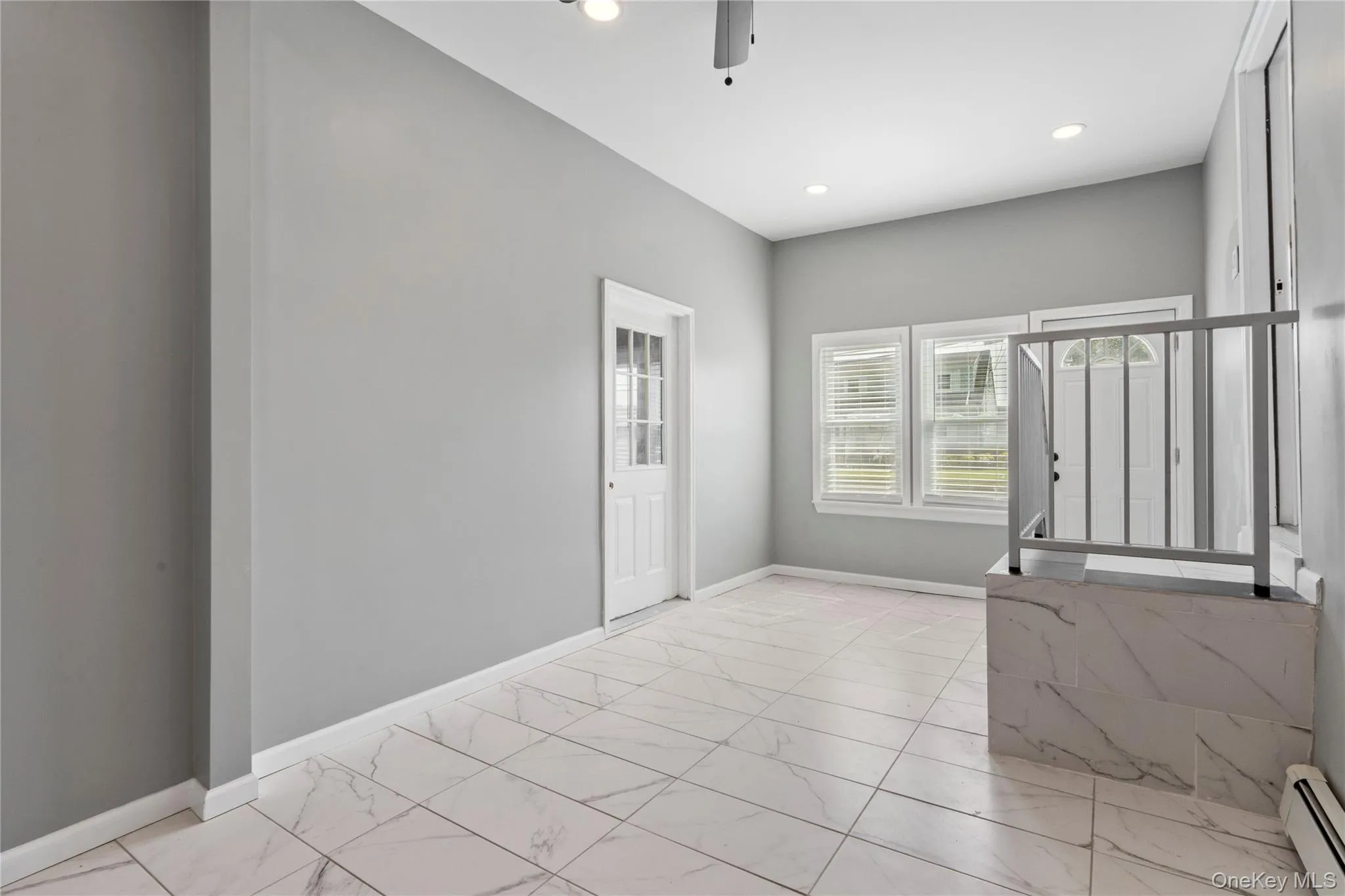 Empty room featuring light marble finish floors, baseboard heating, recessed lighting, and ceiling fan Empty room featuring light marble finish floors, baseboard heating, recessed lighting, and ceiling fan