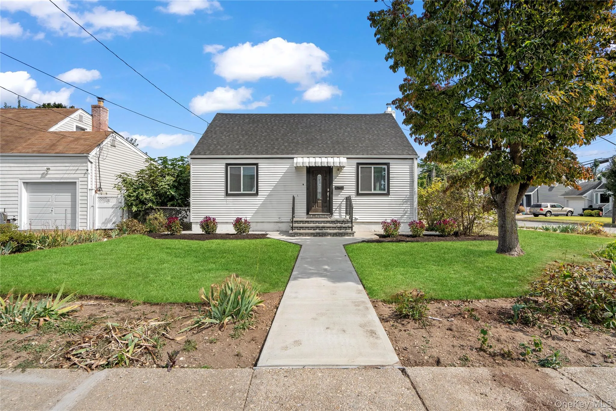 View of front of home with a front lawn and a shingled roof View of front of home with a front lawn and a shingled roof