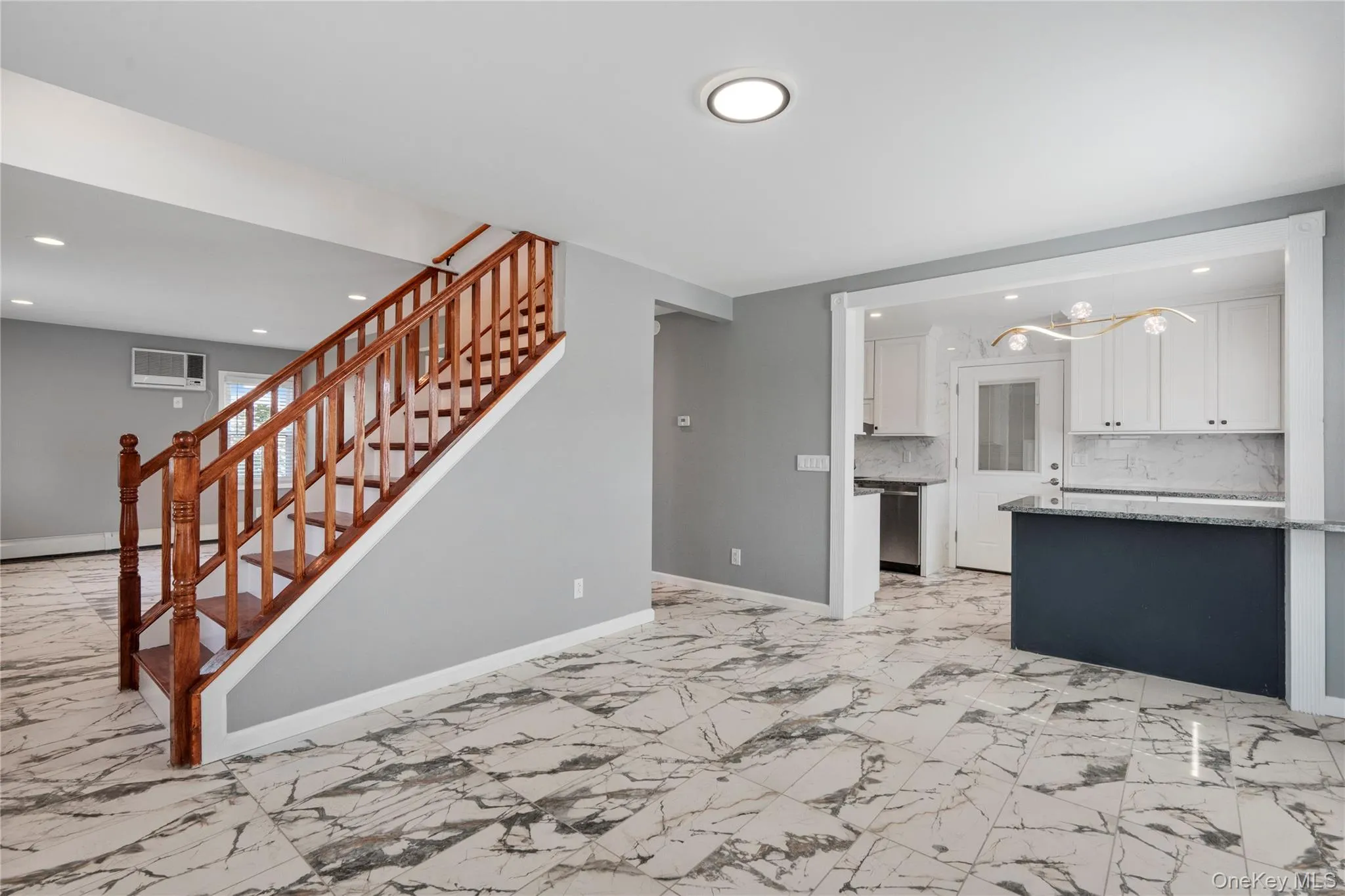 Unfurnished living room featuring recessed lighting, light marble finish floors, a chandelier, and stairs Unfurnished living room featuring recessed lighting, light marble finish floors, a chandelier, and stairs