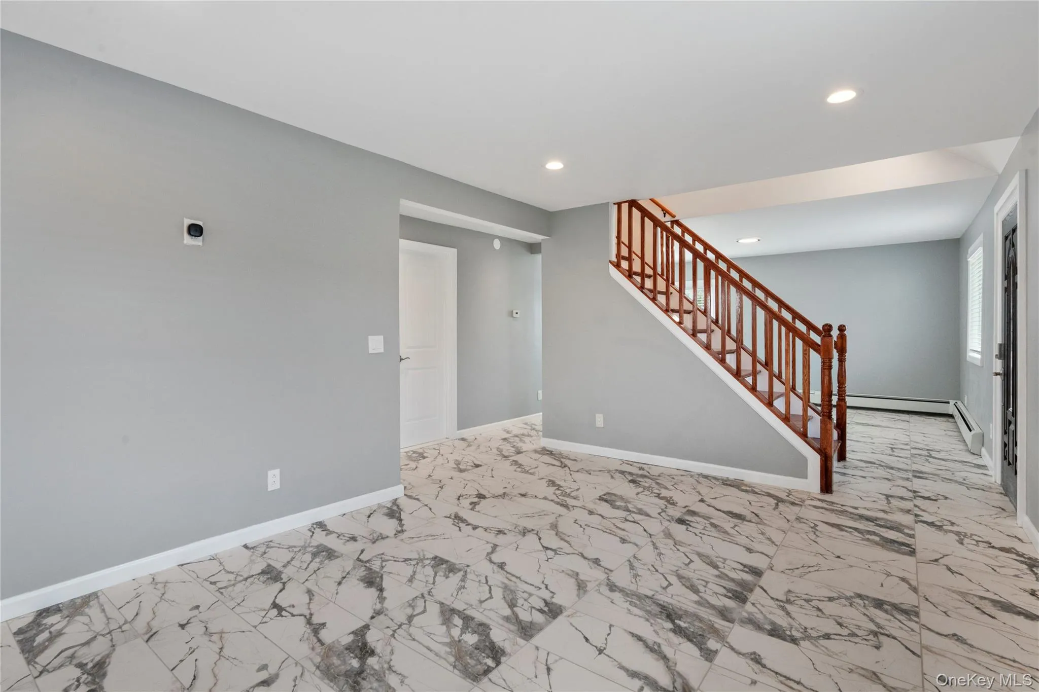 Unfurnished living room featuring light marble finish flooring, recessed lighting, and stairway Unfurnished living room featuring light marble finish flooring, recessed lighting, and stairway