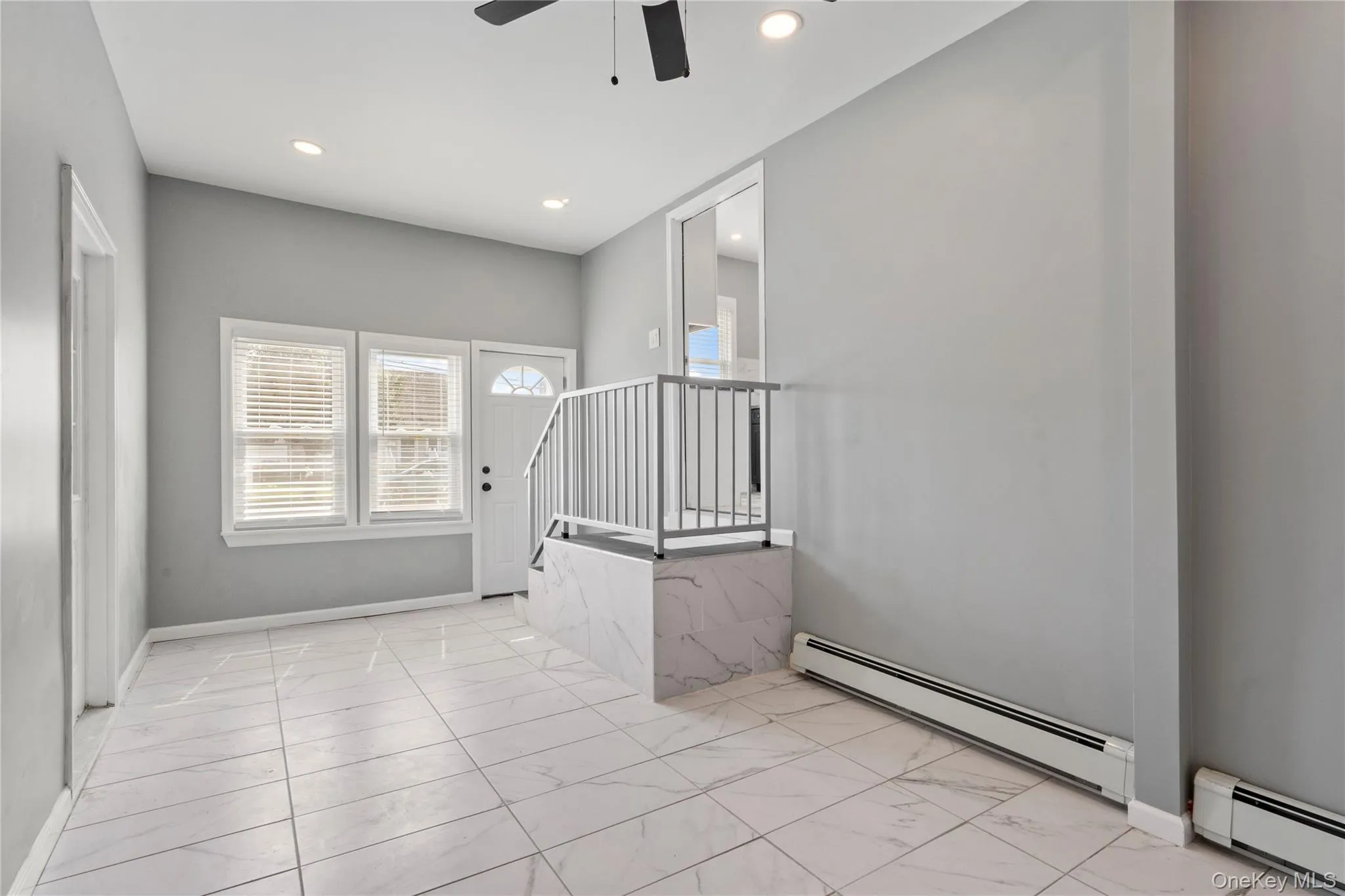 Spare room with baseboard heating, recessed lighting, and light marble finish flooring Spare room with baseboard heating, recessed lighting, and light marble finish flooring