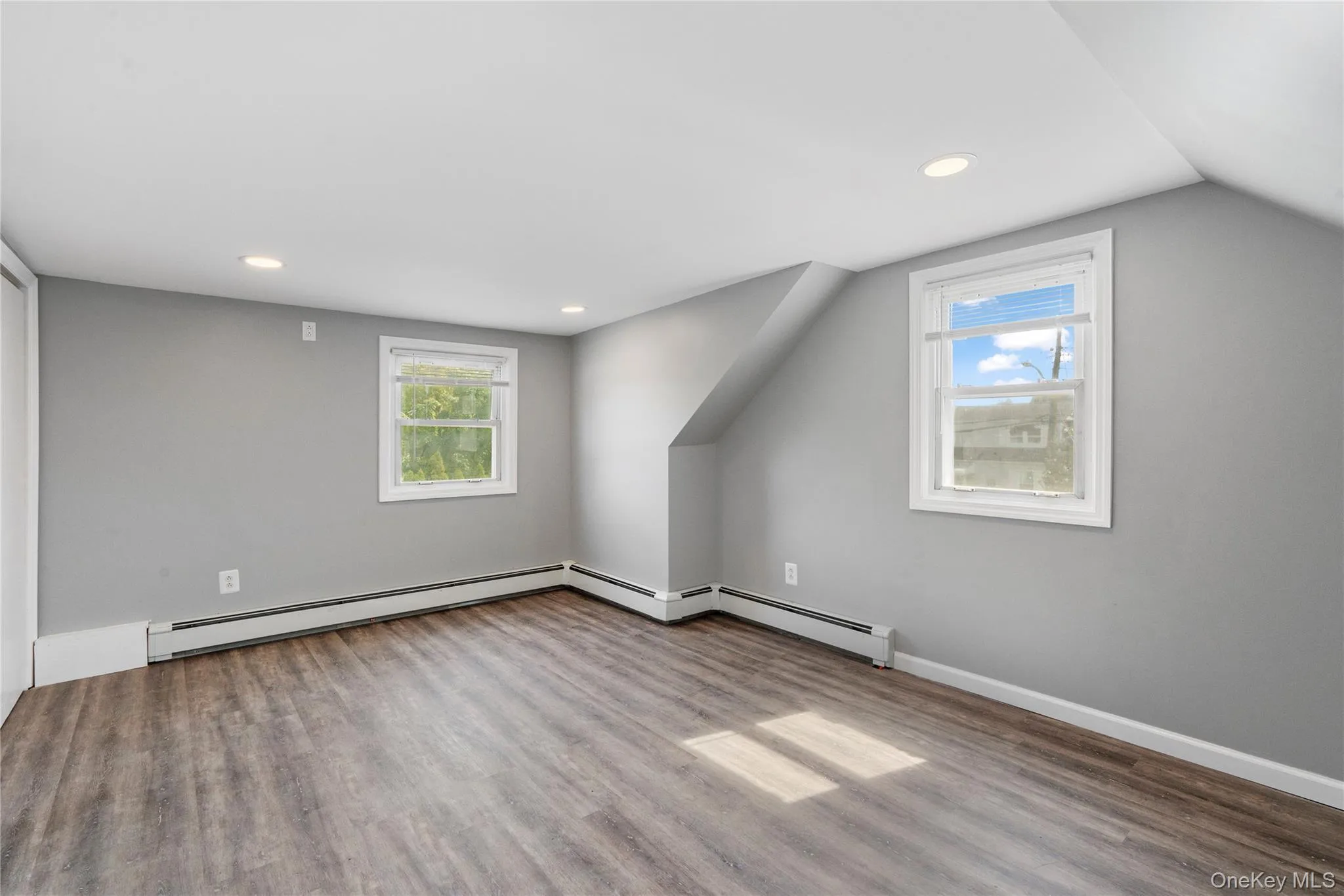 Additional living space with wood finished floors, recessed lighting, a baseboard radiator, and lofted ceiling Additional living space with wood finished floors, recessed lighting, a baseboard radiator, and lofted ceiling