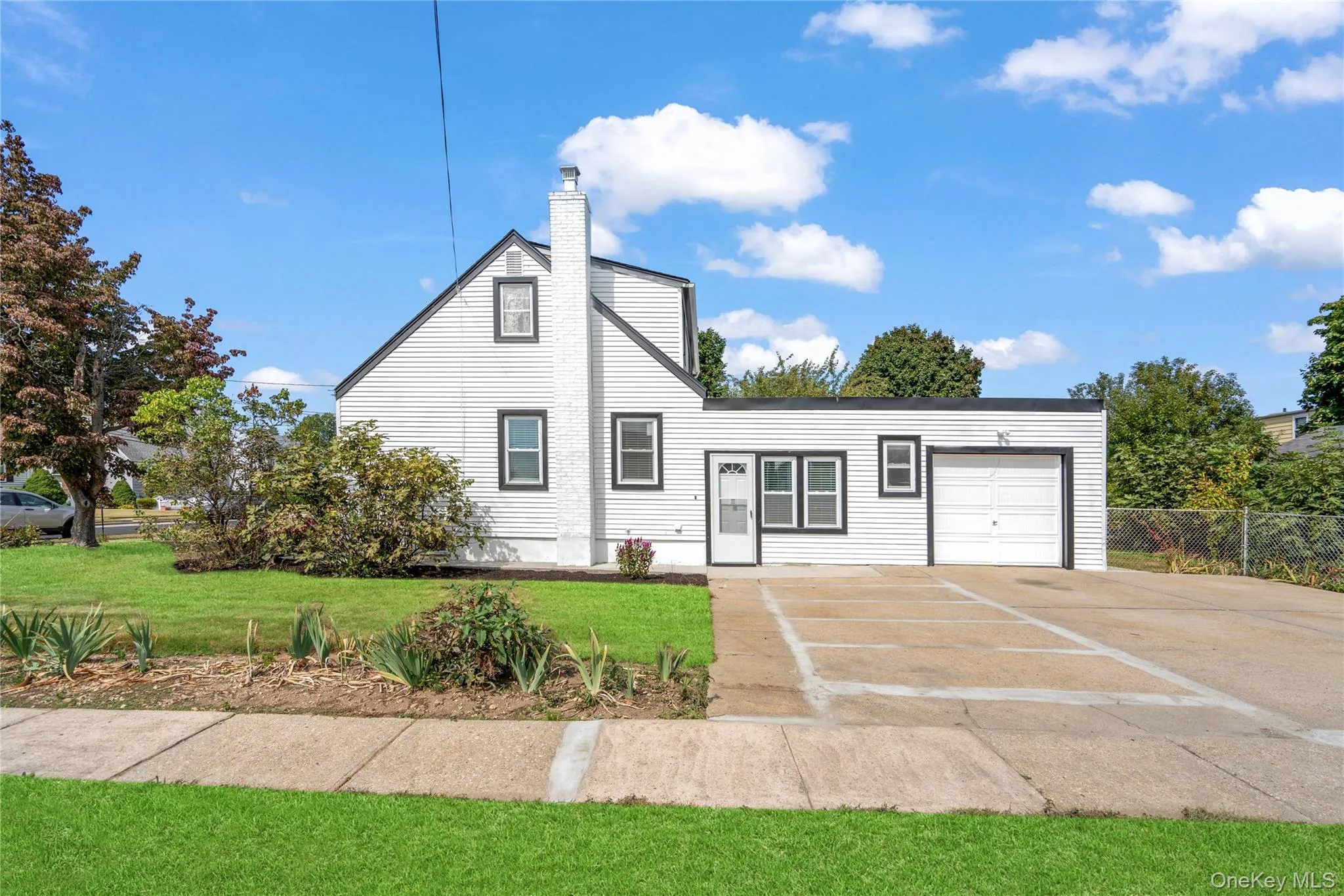 View of front of house featuring driveway, a chimney, and an attached garage View of front of house featuring driveway, a chimney, and an attached garage