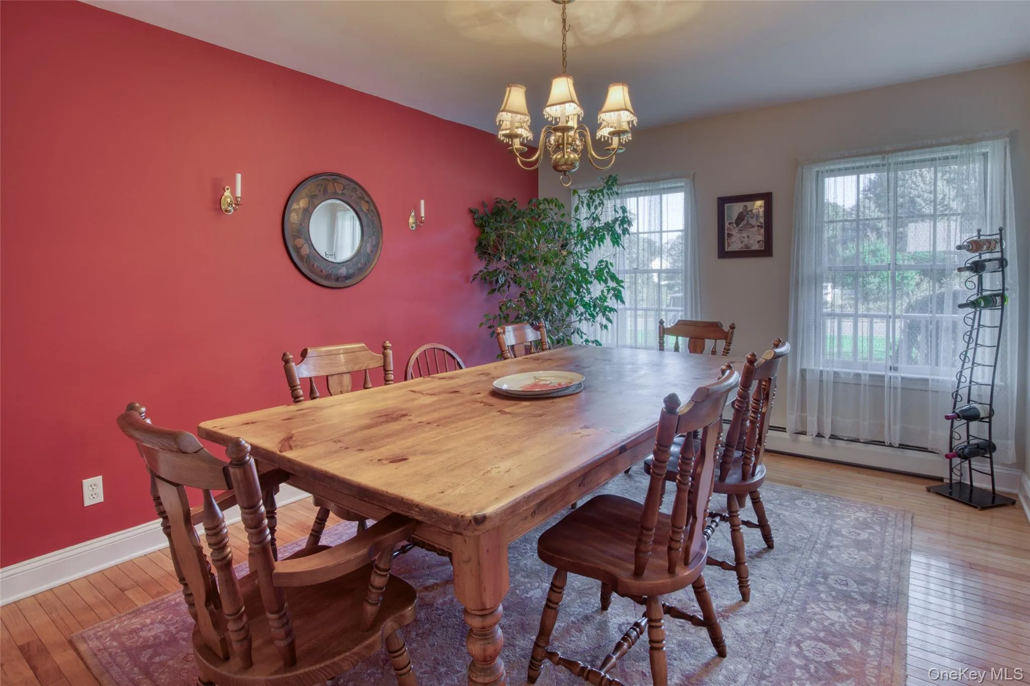 Dining room featuring light wood-style floors, a chandelier, and a baseboard heating unit Dining room featuring light wood-style floors, a chandelier, and a baseboard heating unit