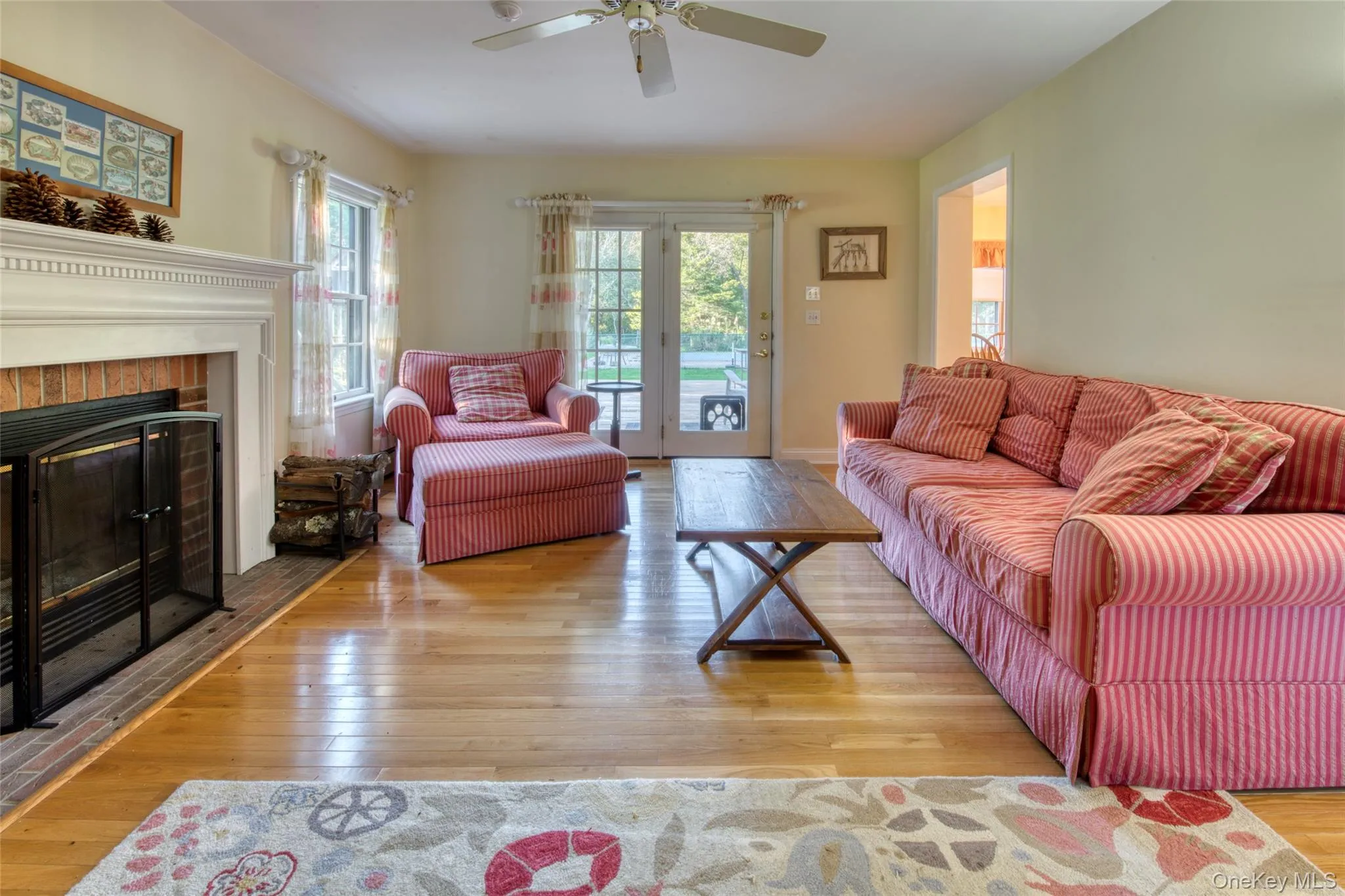 Living area featuring wood-type flooring and a brick fireplace Living area featuring wood-type flooring and a brick fireplace