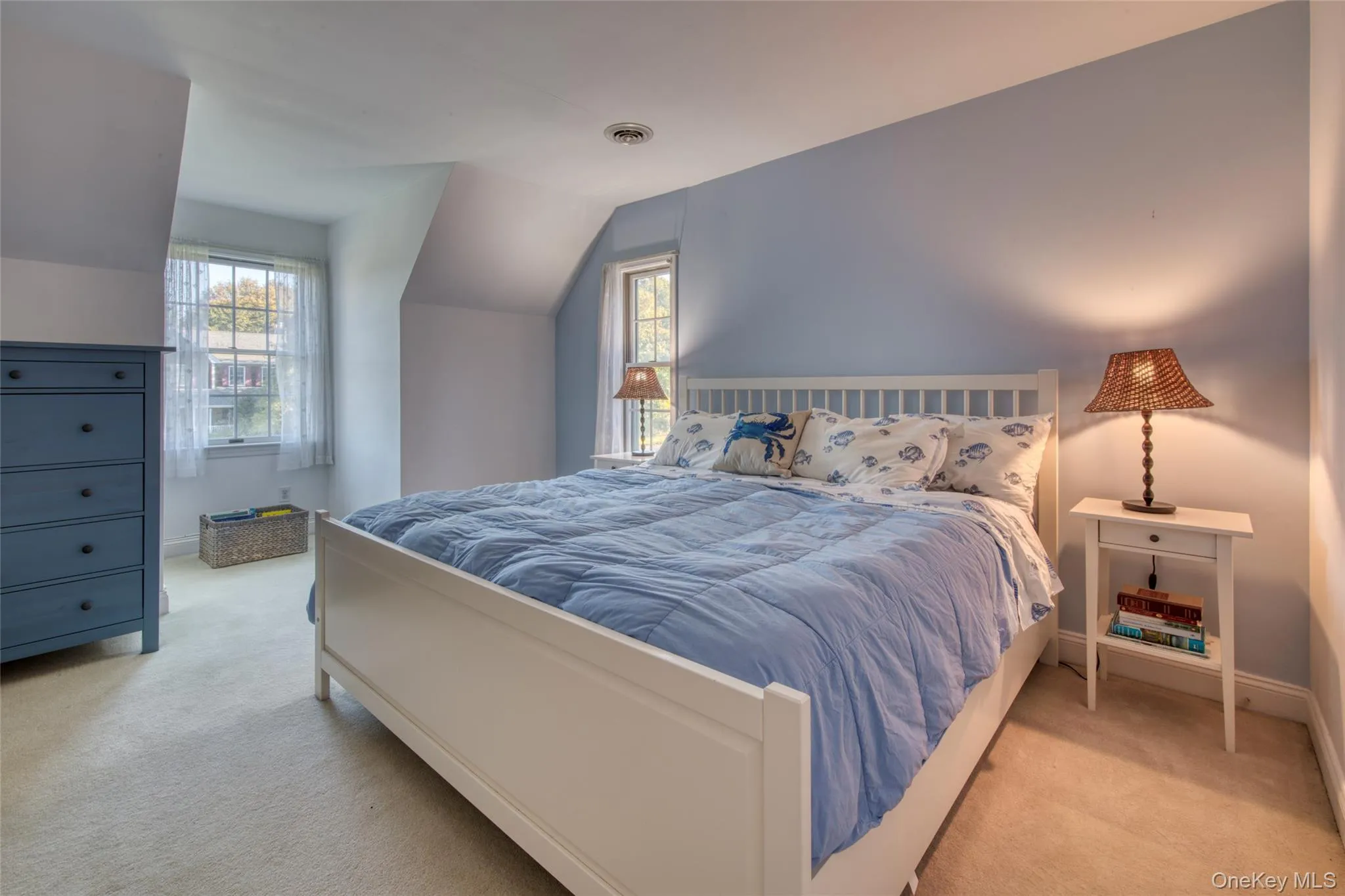 Bedroom featuring multiple windows, light carpet, and vaulted ceiling Bedroom featuring multiple windows, light carpet, and vaulted ceiling