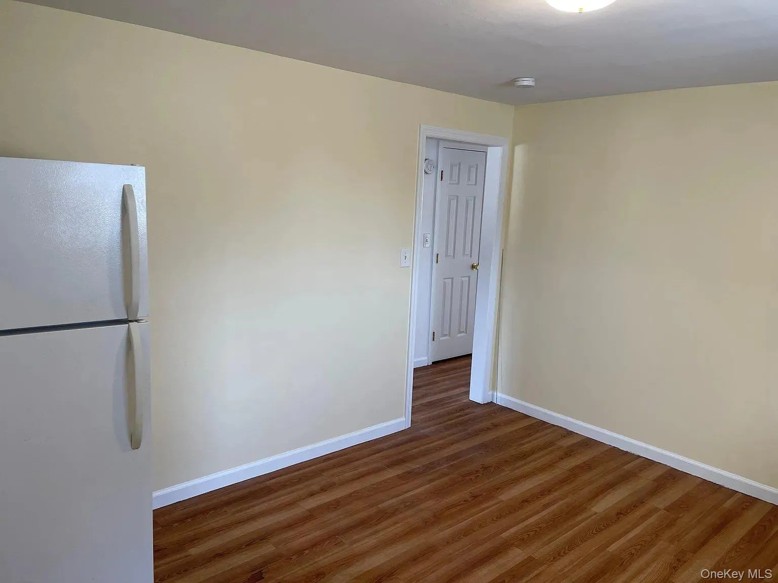 Unfurnished room featuring dark wood-style flooring Unfurnished room featuring dark wood-style flooring