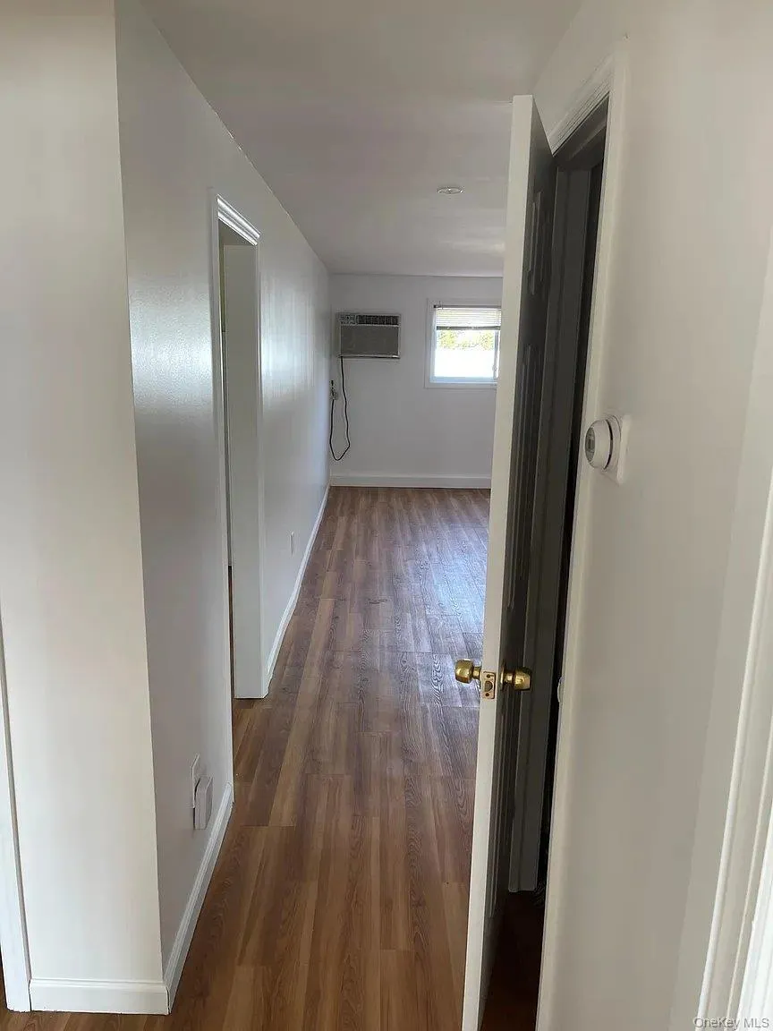 Hall featuring dark wood-type flooring and a wall unit AC Hall featuring dark wood-type flooring and a wall unit AC