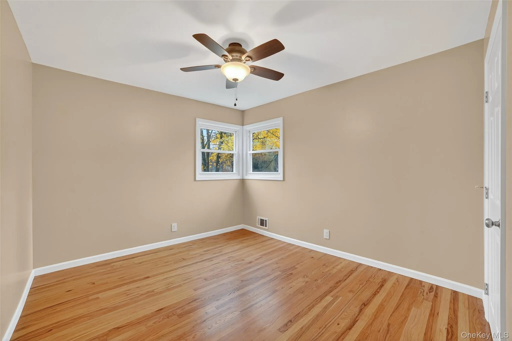 Unfurnished room with light wood-type flooring and a ceiling fan Unfurnished room with light wood-type flooring and a ceiling fan