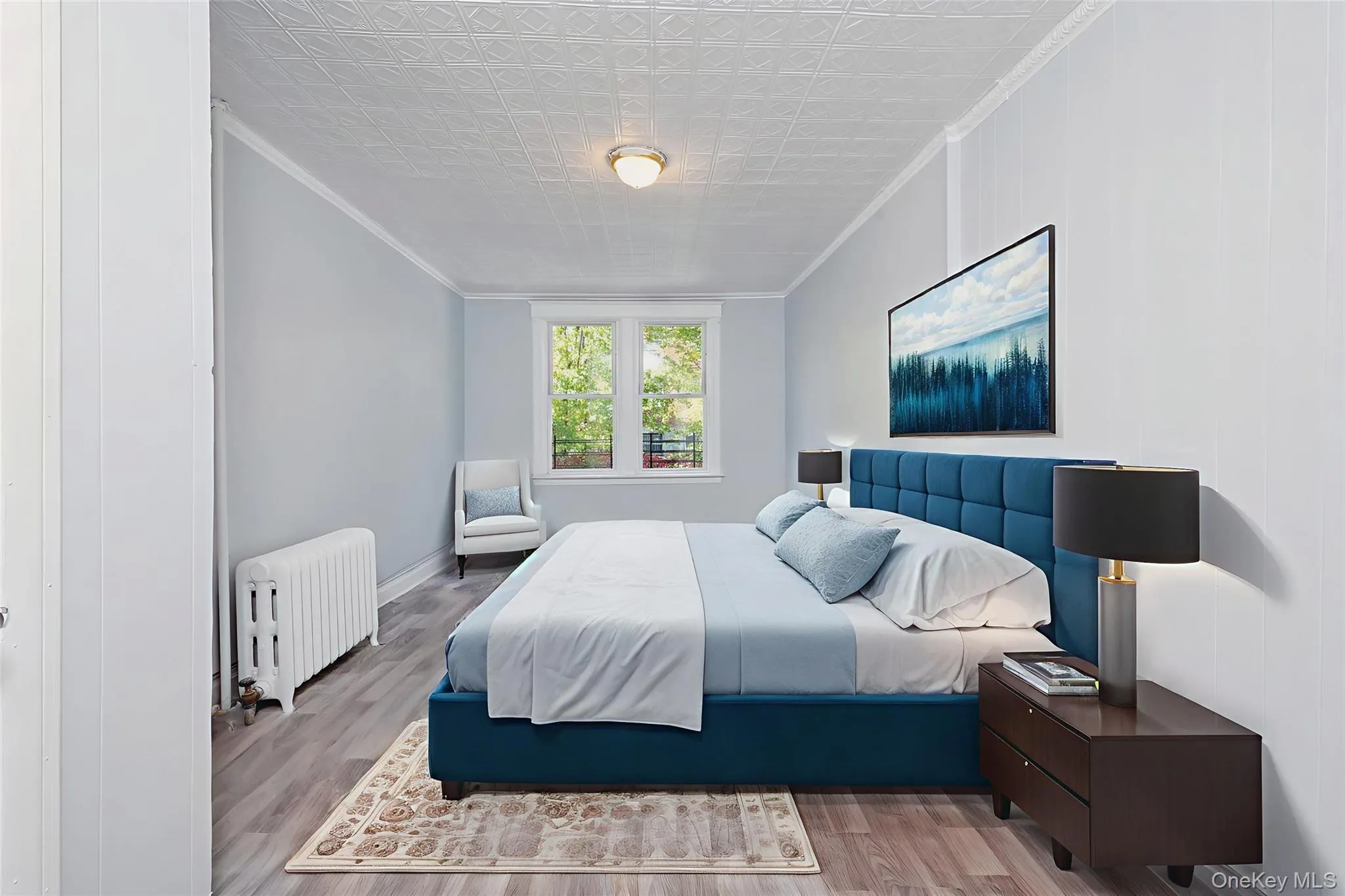 Bedroom featuring ornamental molding, radiator, wood finished floors, and an ornate ceiling Bedroom featuring ornamental molding, radiator, wood finished floors, and an ornate ceiling