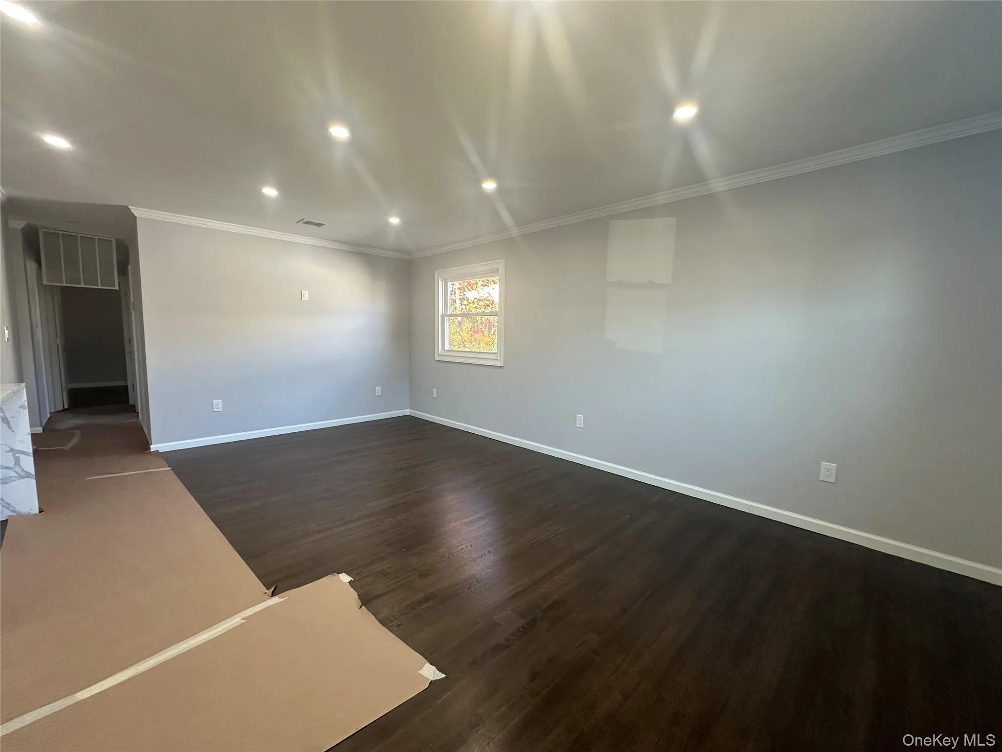 Unfurnished room with recessed lighting, ornamental molding, and dark wood-style flooring Unfurnished room with recessed lighting, ornamental molding, and dark wood-style flooring