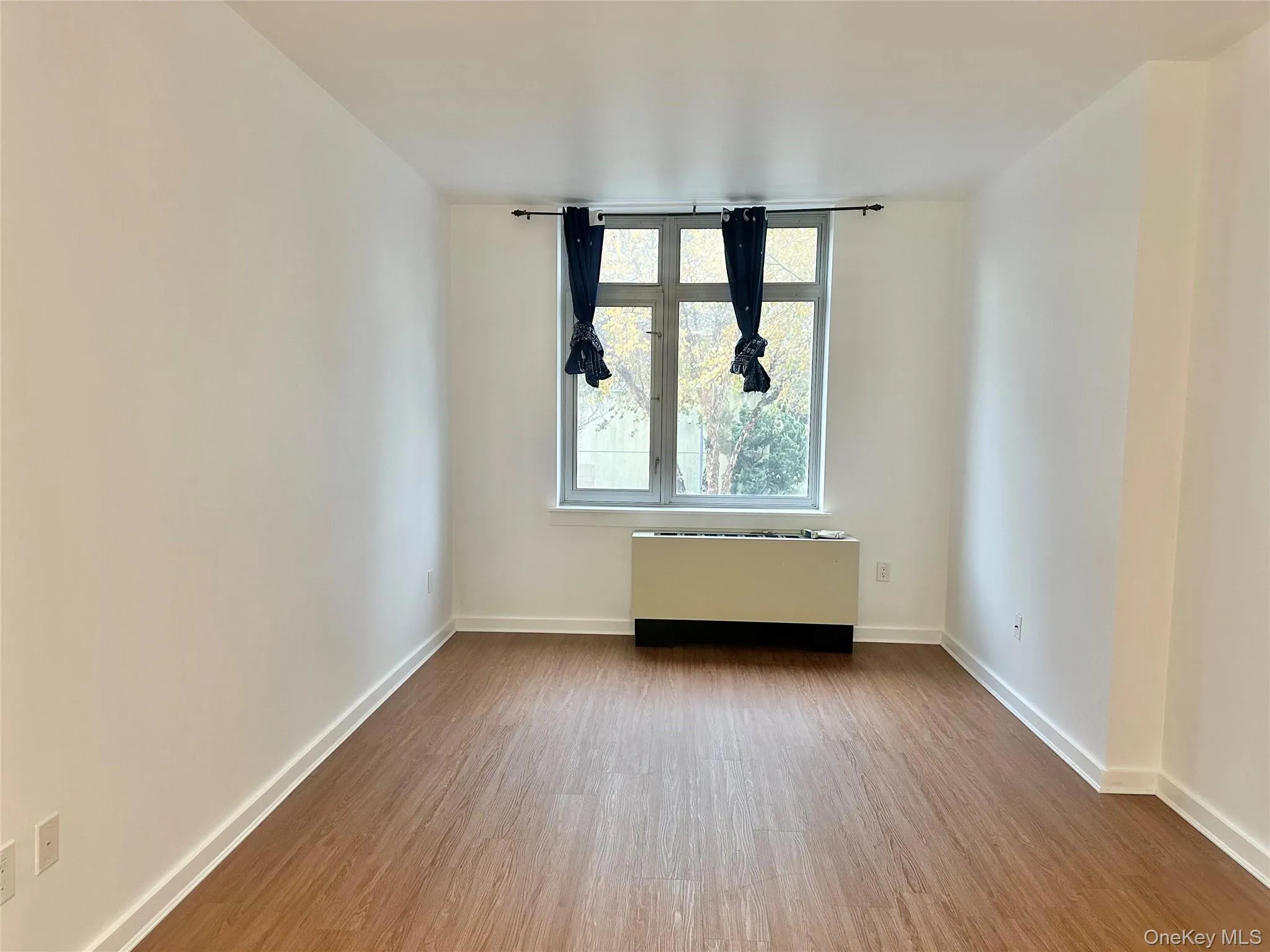 Spare room with radiator and wood finished floors Spare room with radiator and wood finished floors