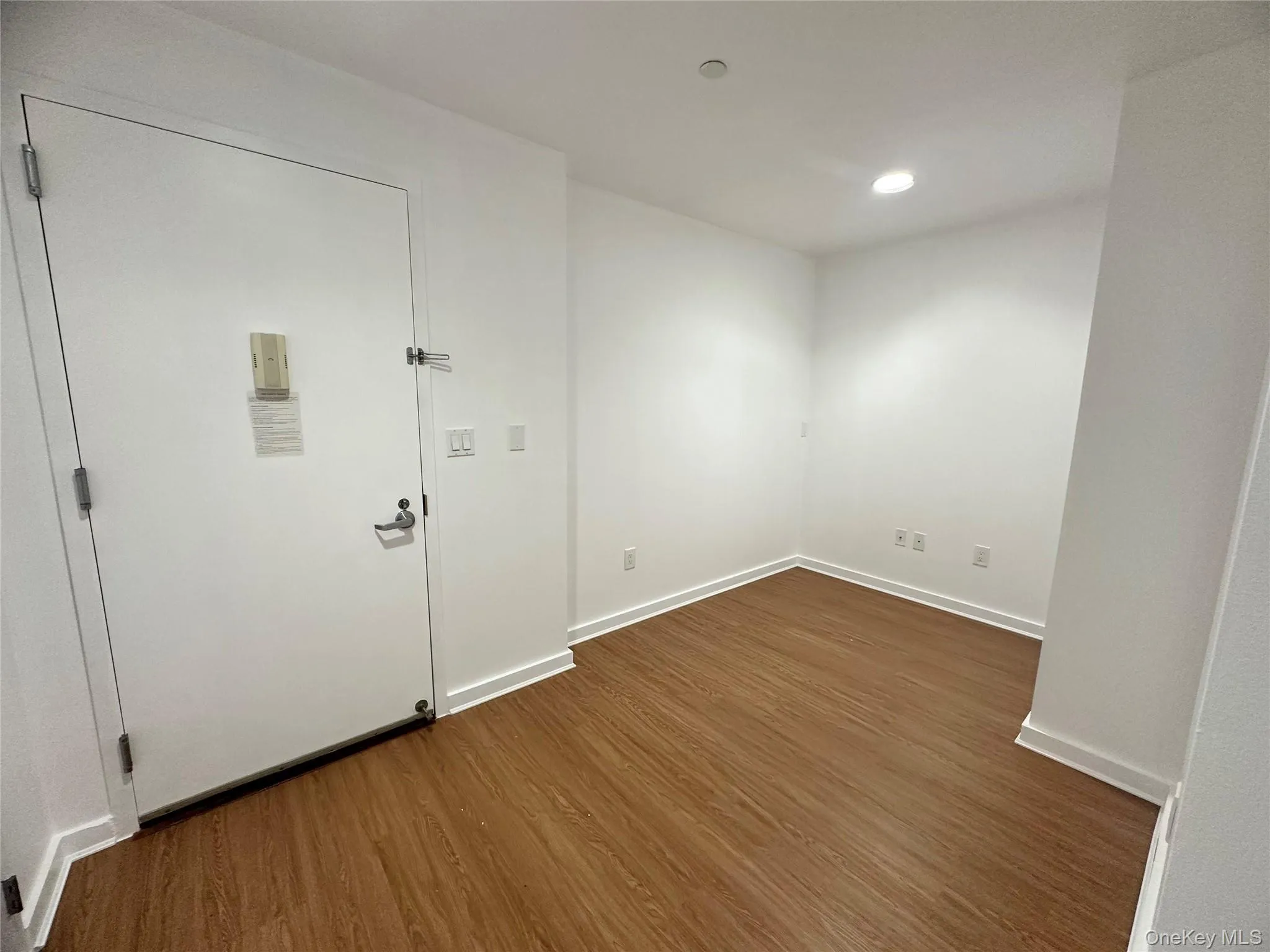 Empty room with dark wood-style floors and recessed lighting Empty room with dark wood-style floors and recessed lighting