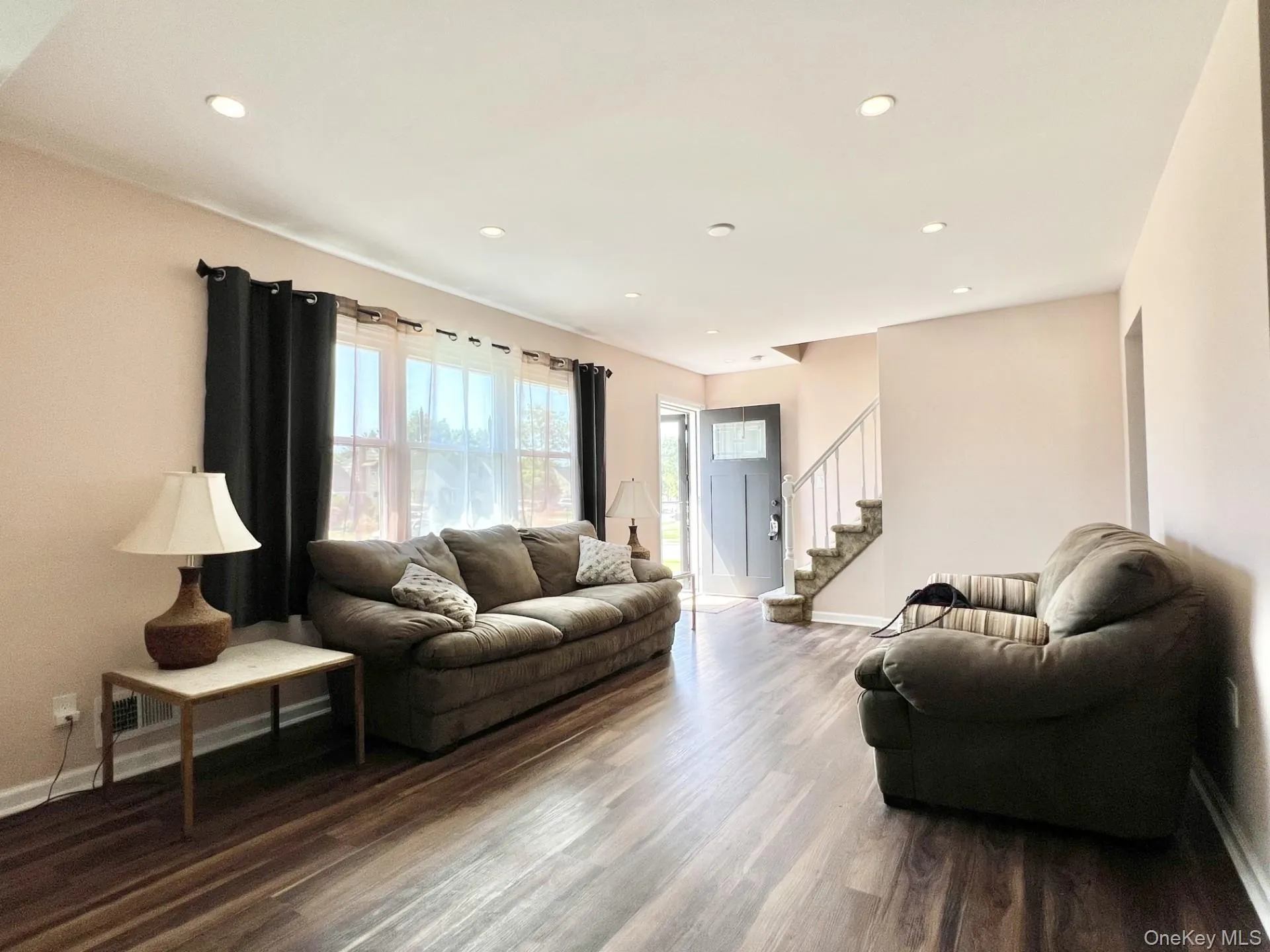 Living room featuring wood finished floors, recessed lighting, and stairway Living room featuring wood finished floors, recessed lighting, and stairway