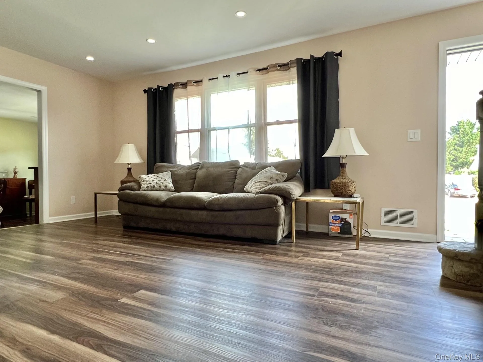 Living area with plenty of natural light, wood finished floors, and recessed lighting Living area with plenty of natural light, wood finished floors, and recessed lighting