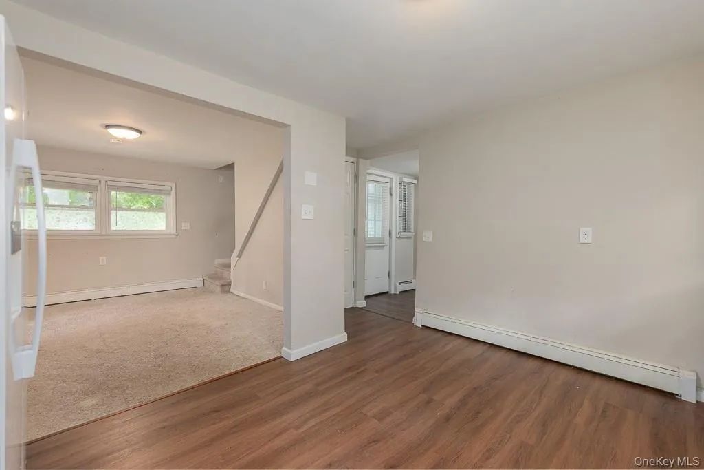 Spare room featuring a baseboard heating unit, wood finished floors, and a baseboard radiator Spare room featuring a baseboard heating unit, wood finished floors, and a baseboard radiator