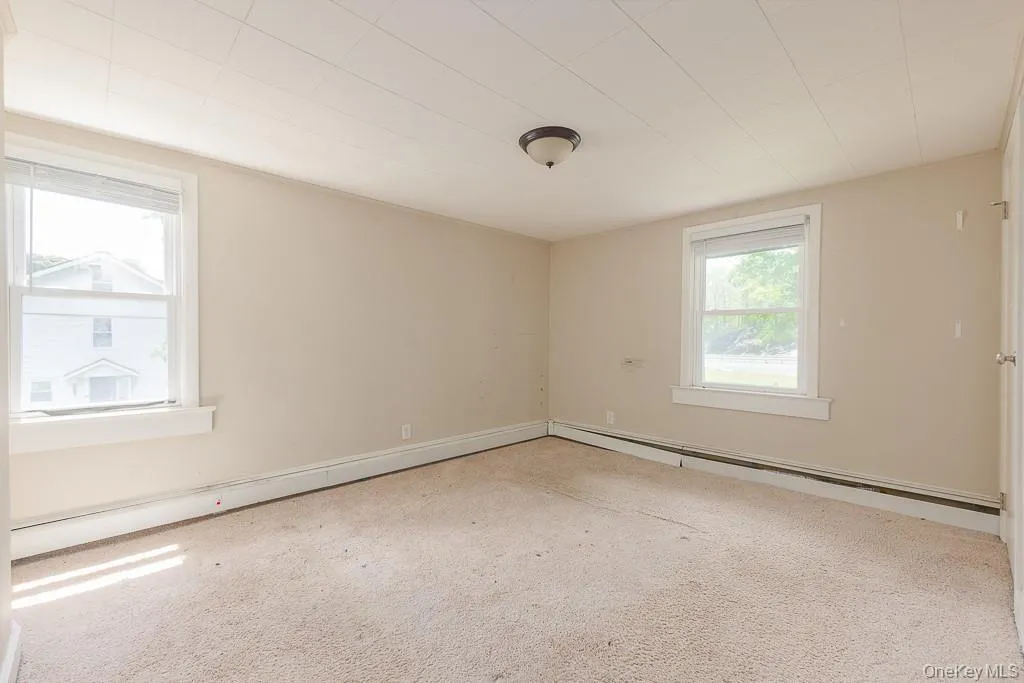 Carpeted spare room featuring a baseboard heating unit Carpeted spare room featuring a baseboard heating unit