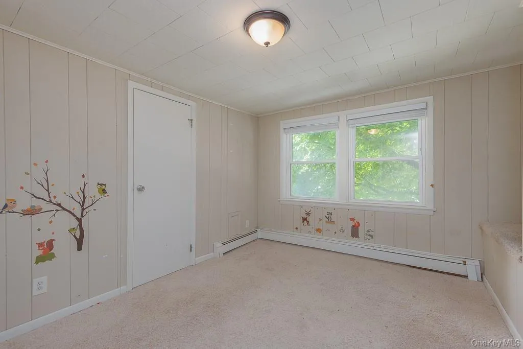 Spare room with light carpet and a baseboard heating unit Spare room with light carpet and a baseboard heating unit