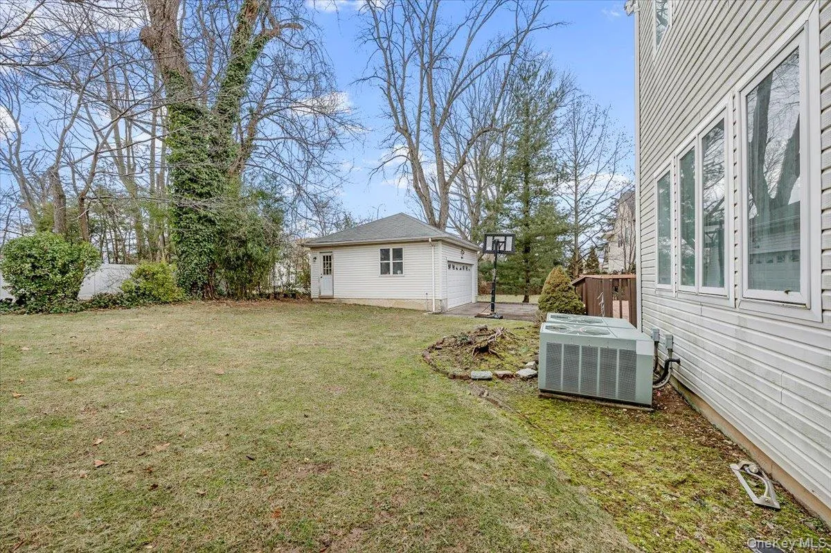 View of green lawn featuring an outbuilding and a garage View of green lawn featuring an outbuilding and a garage
