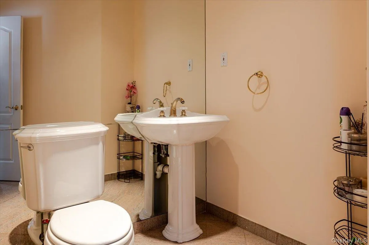 Half bathroom with toilet and light tile patterned floors Half bathroom with toilet and light tile patterned floors