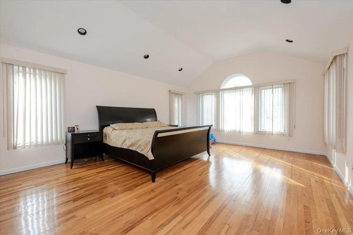 Bedroom with lofted ceiling, light wood-style floors, and recessed lighting Bedroom with lofted ceiling, light wood-style floors, and recessed lighting
