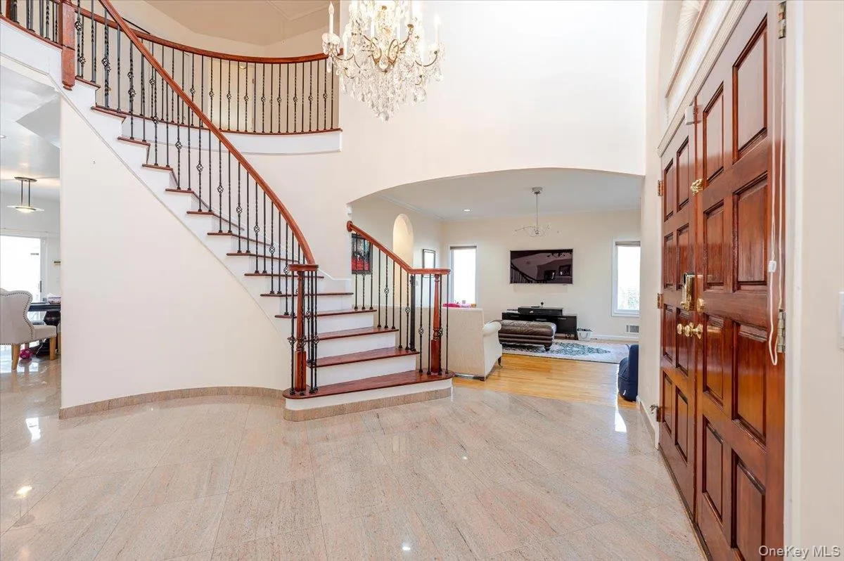 Staircase with a high ceiling, arched walkways, a chandelier, and crown molding Staircase with a high ceiling, arched walkways, a chandelier, and crown molding