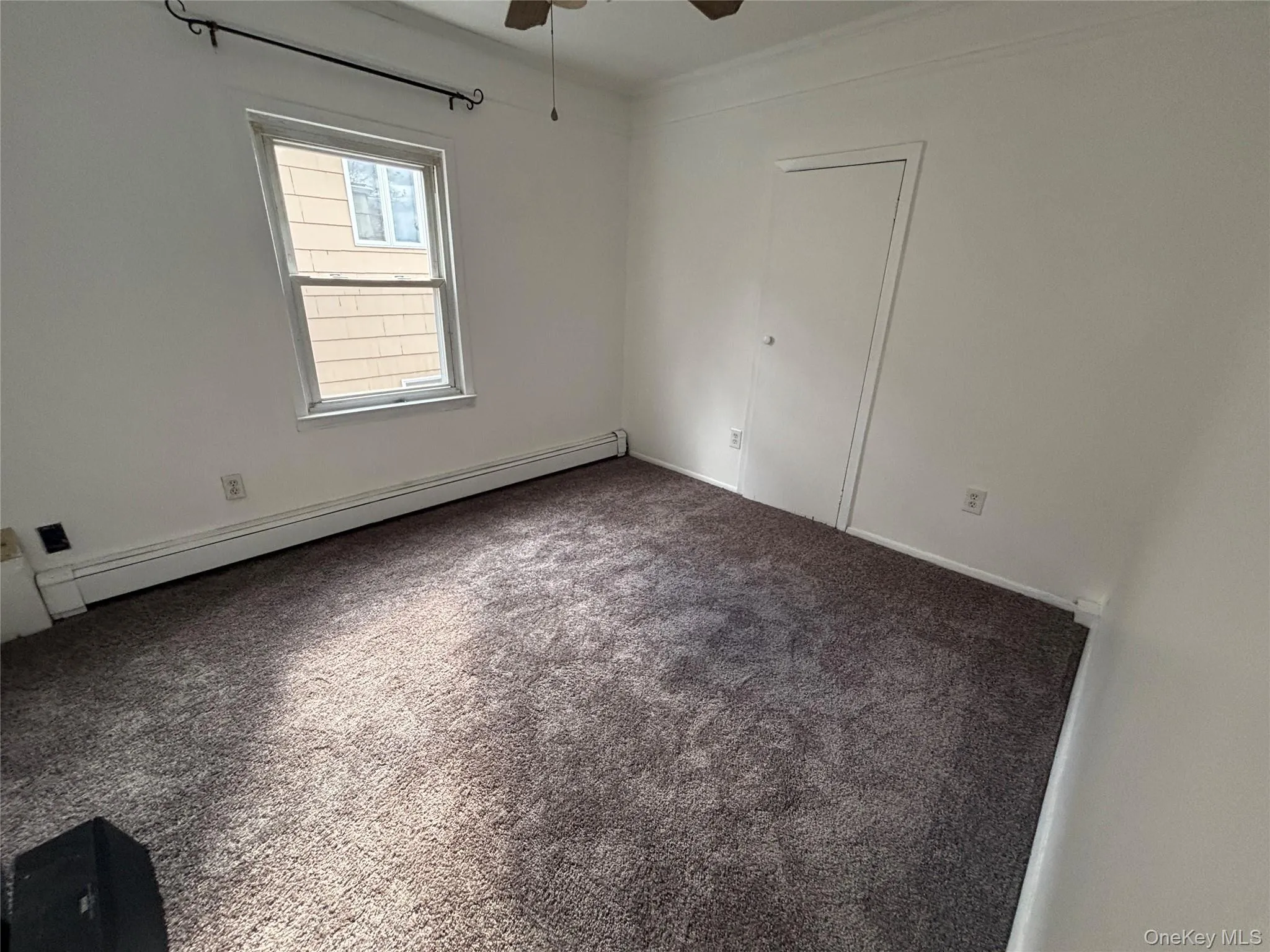 Carpeted spare room featuring a baseboard heating unit and ceiling fan Carpeted spare room featuring a baseboard heating unit and ceiling fan
