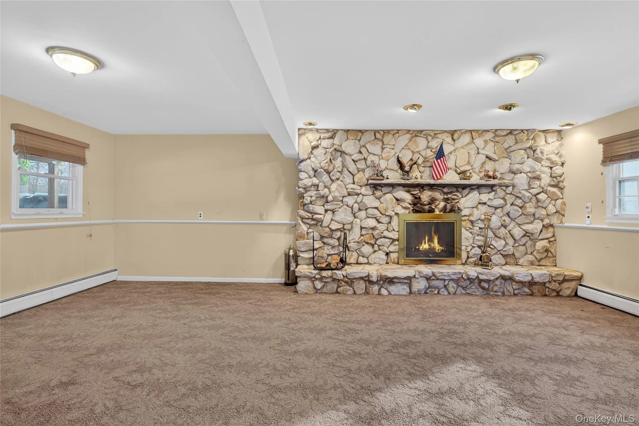 Unfurnished living room featuring a fireplace, carpet flooring, and beam ceiling Unfurnished living room featuring a fireplace, carpet flooring, and beam ceiling