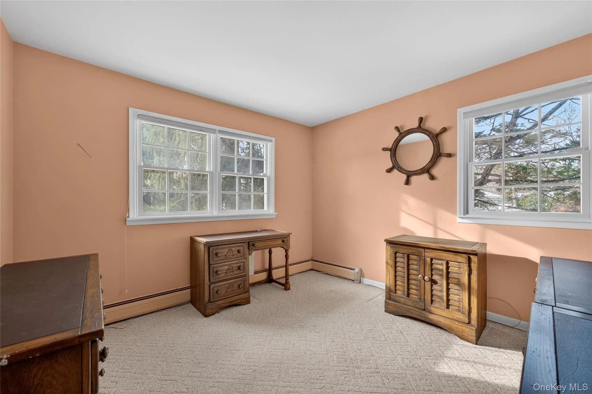 Office area featuring light colored carpet and a baseboard heating unit Office area featuring light colored carpet and a baseboard heating unit