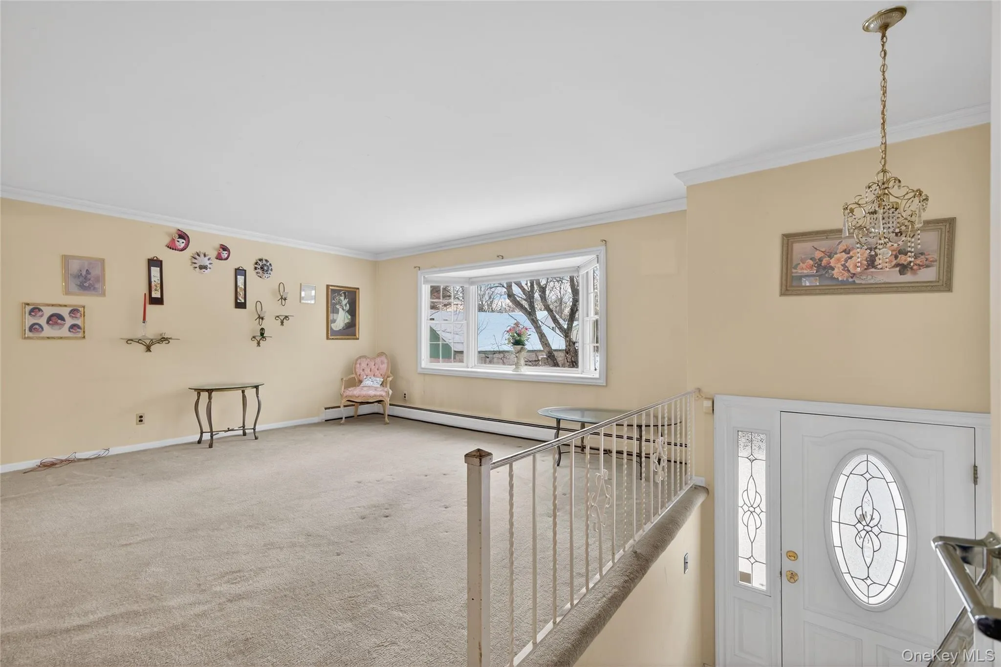 Foyer with ornamental molding, carpet floors, and a chandelier Foyer with ornamental molding, carpet floors, and a chandelier