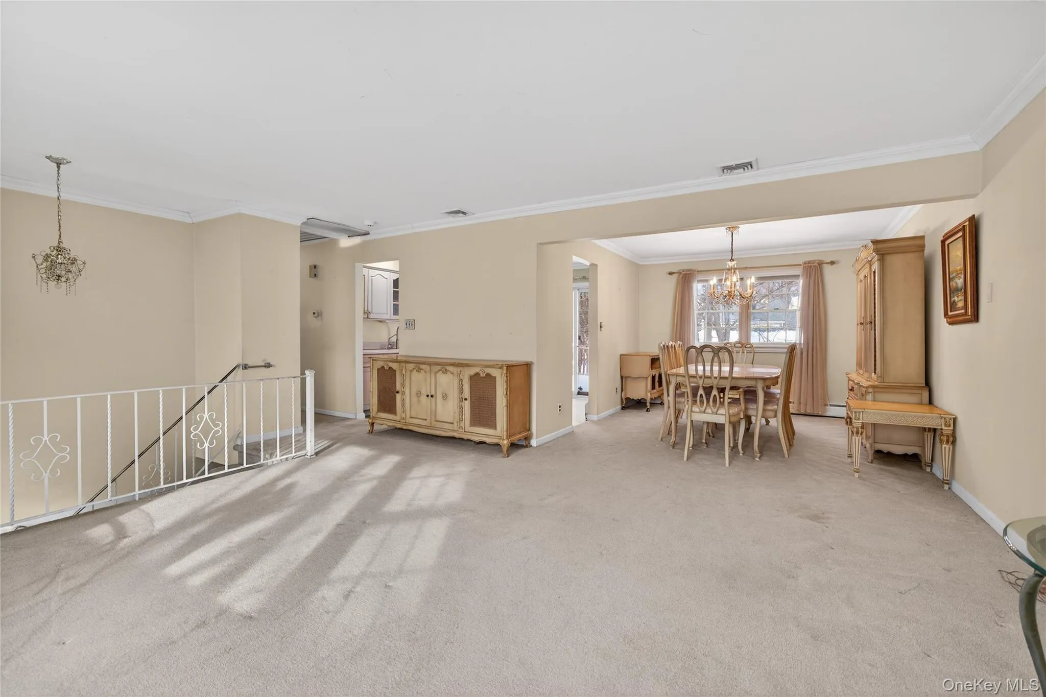 Living area featuring a chandelier, carpet flooring, and ornamental molding Living area featuring a chandelier, carpet flooring, and ornamental molding