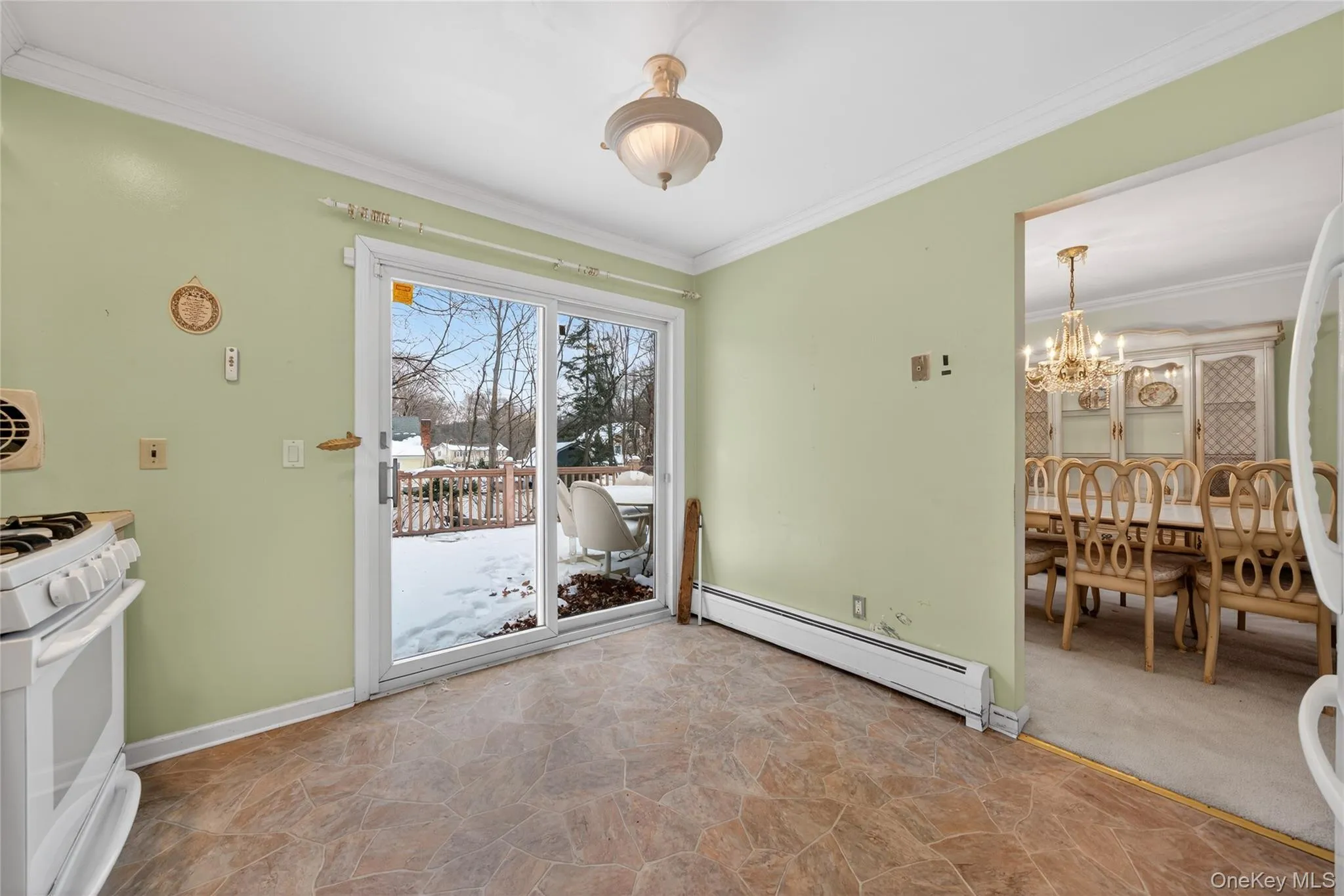 Unfurnished dining area featuring stone finish floors, a baseboard heating unit, a chandelier, and crown molding Unfurnished dining area featuring stone finish floors, a baseboard heating unit, a chandelier, and crown molding