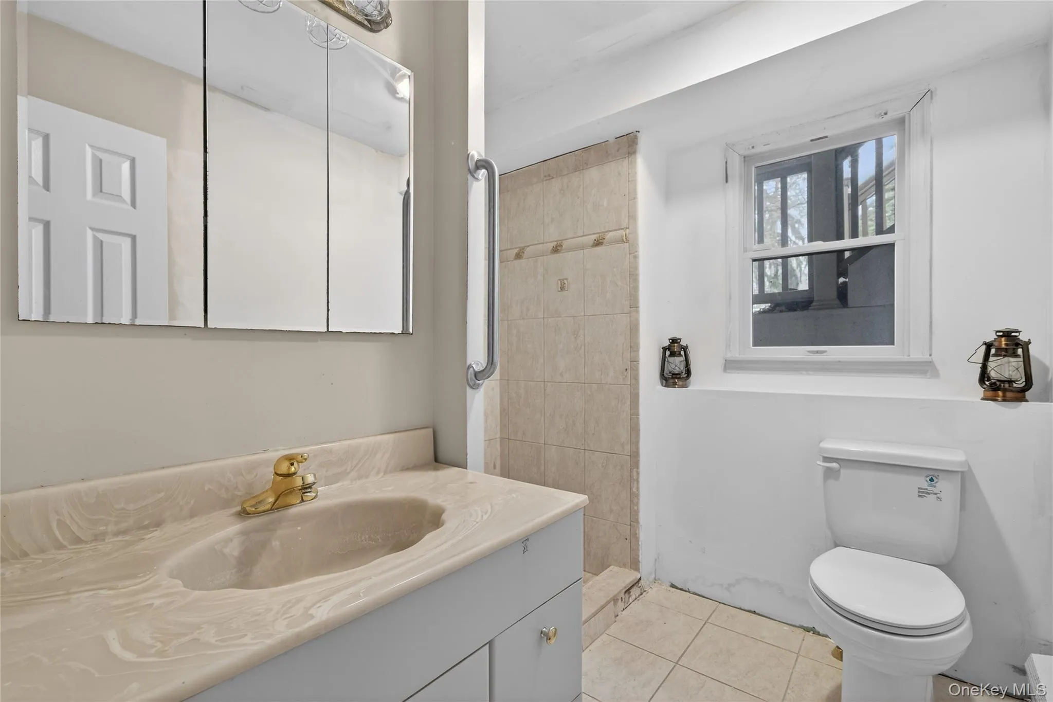Full bathroom with vanity, light tile patterned floors, and tiled shower Full bathroom with vanity, light tile patterned floors, and tiled shower