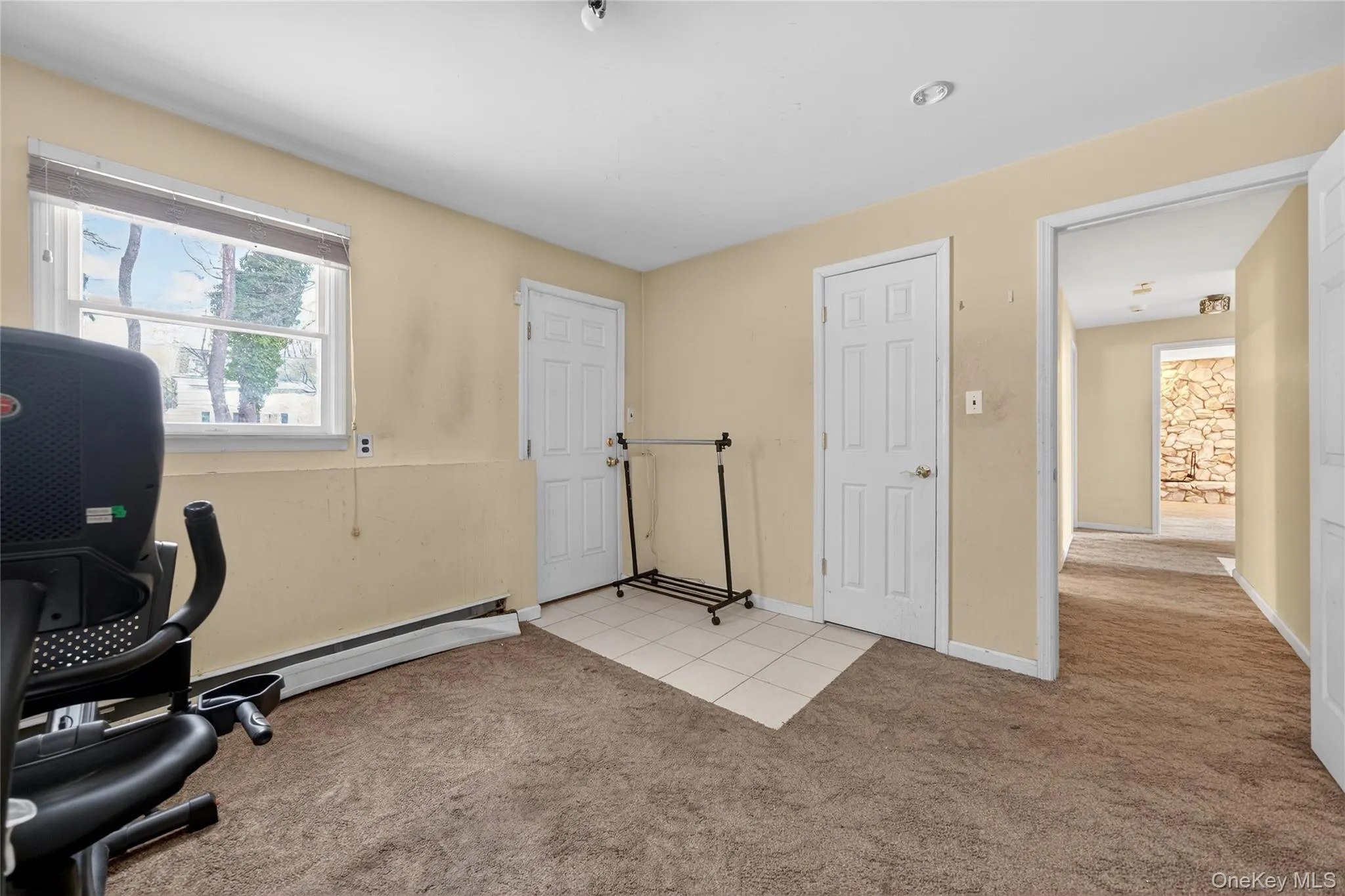 Home office featuring light colored carpet and light tile patterned flooring Home office featuring light colored carpet and light tile patterned flooring