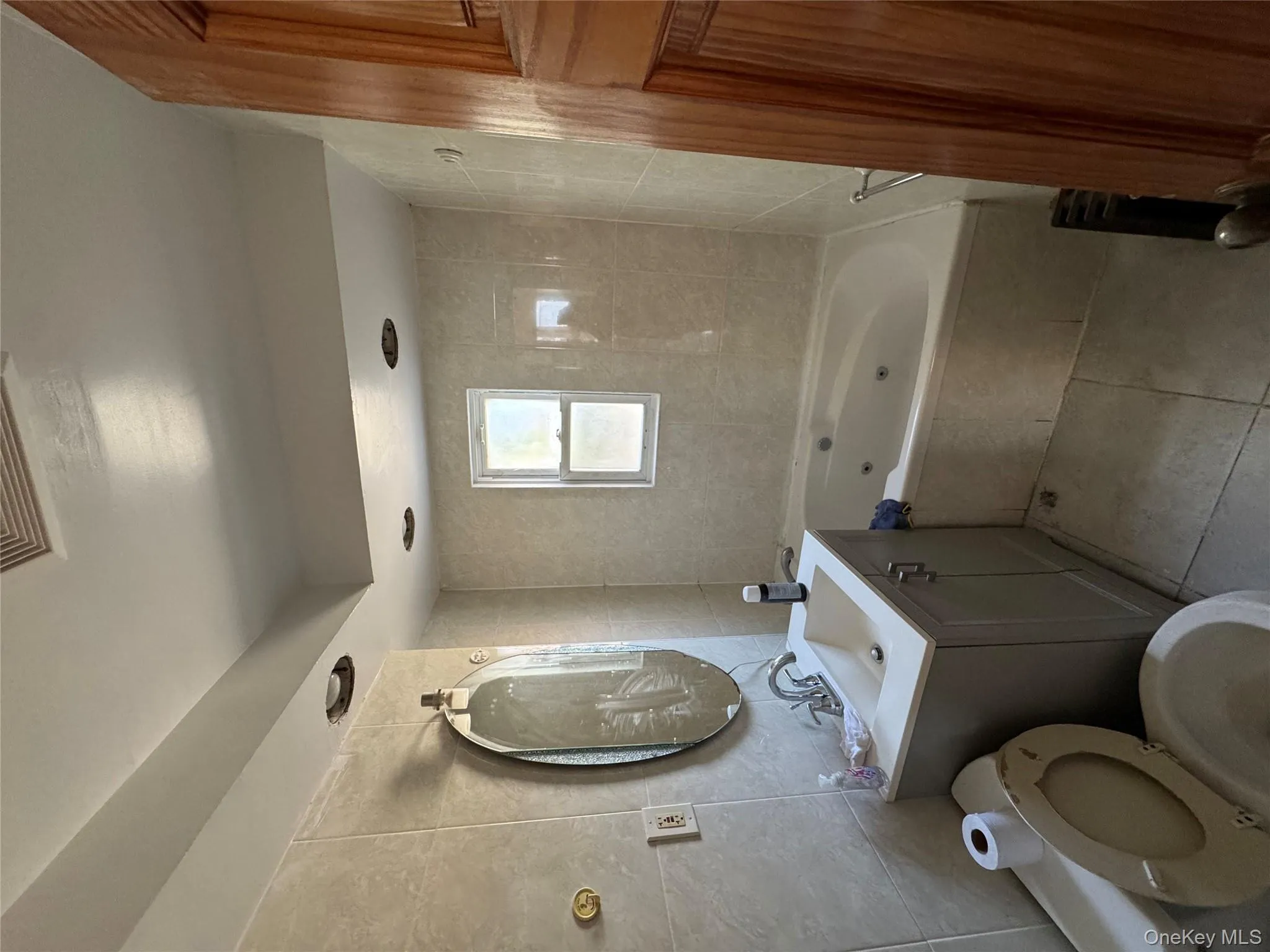 Bathroom featuring tile walls, vanity, and light tile patterned flooring Bathroom featuring tile walls, vanity, and light tile patterned flooring