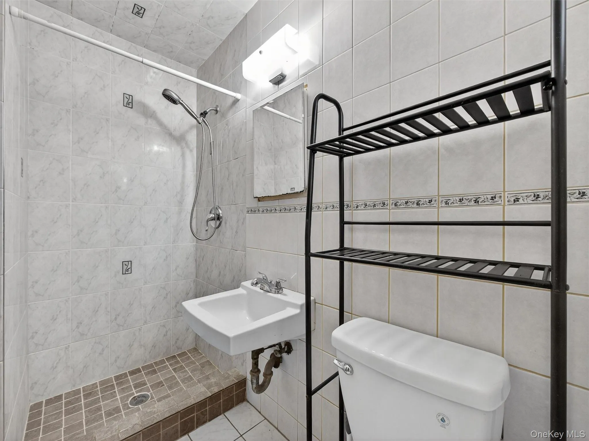 Bathroom with a shower stall and tile walls Bathroom with a shower stall and tile walls